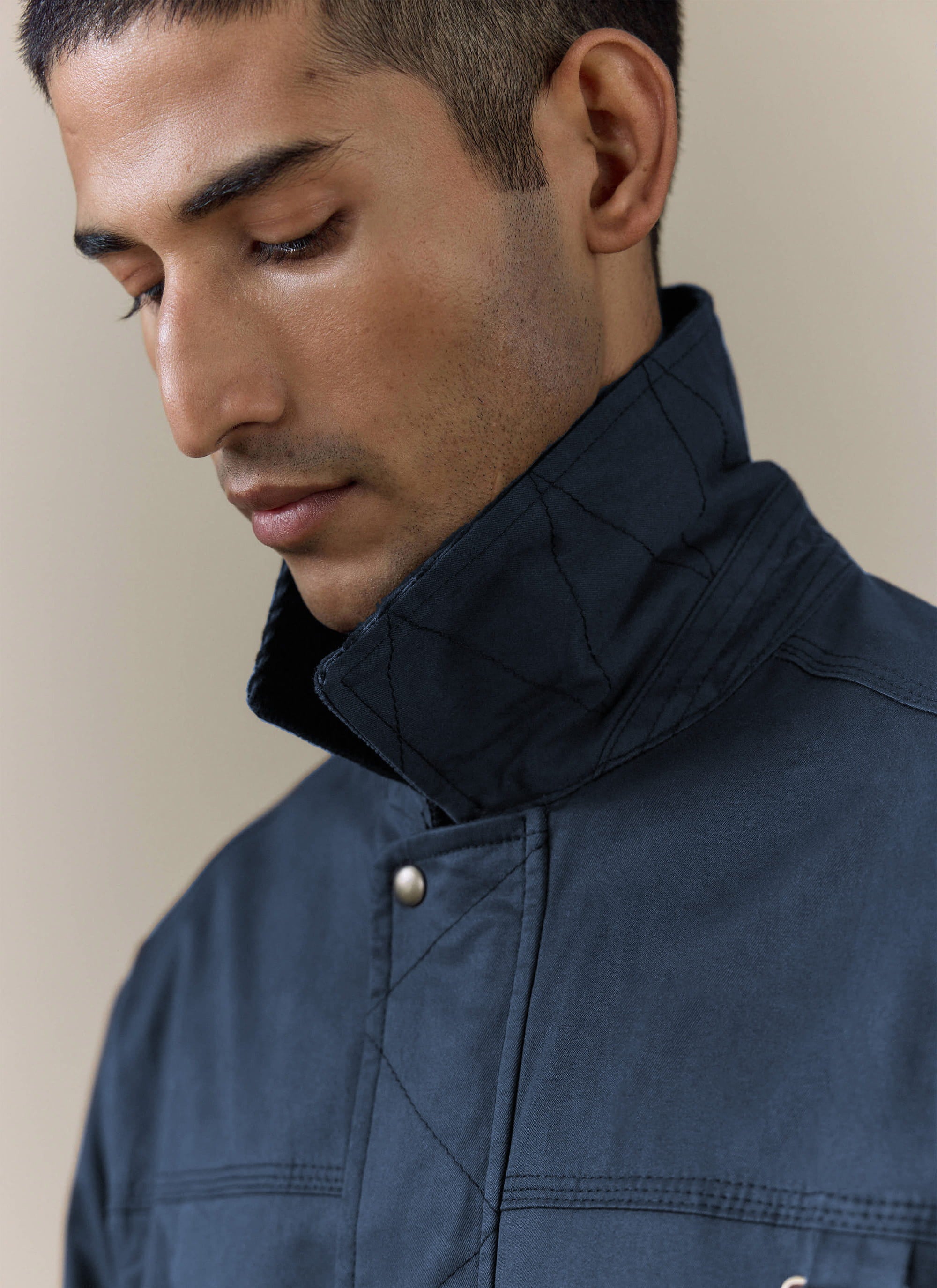Close-up of the navy blue Percival Wax Zip Jacket collar, featuring a waxed cotton finish and diamond stitch detailing.