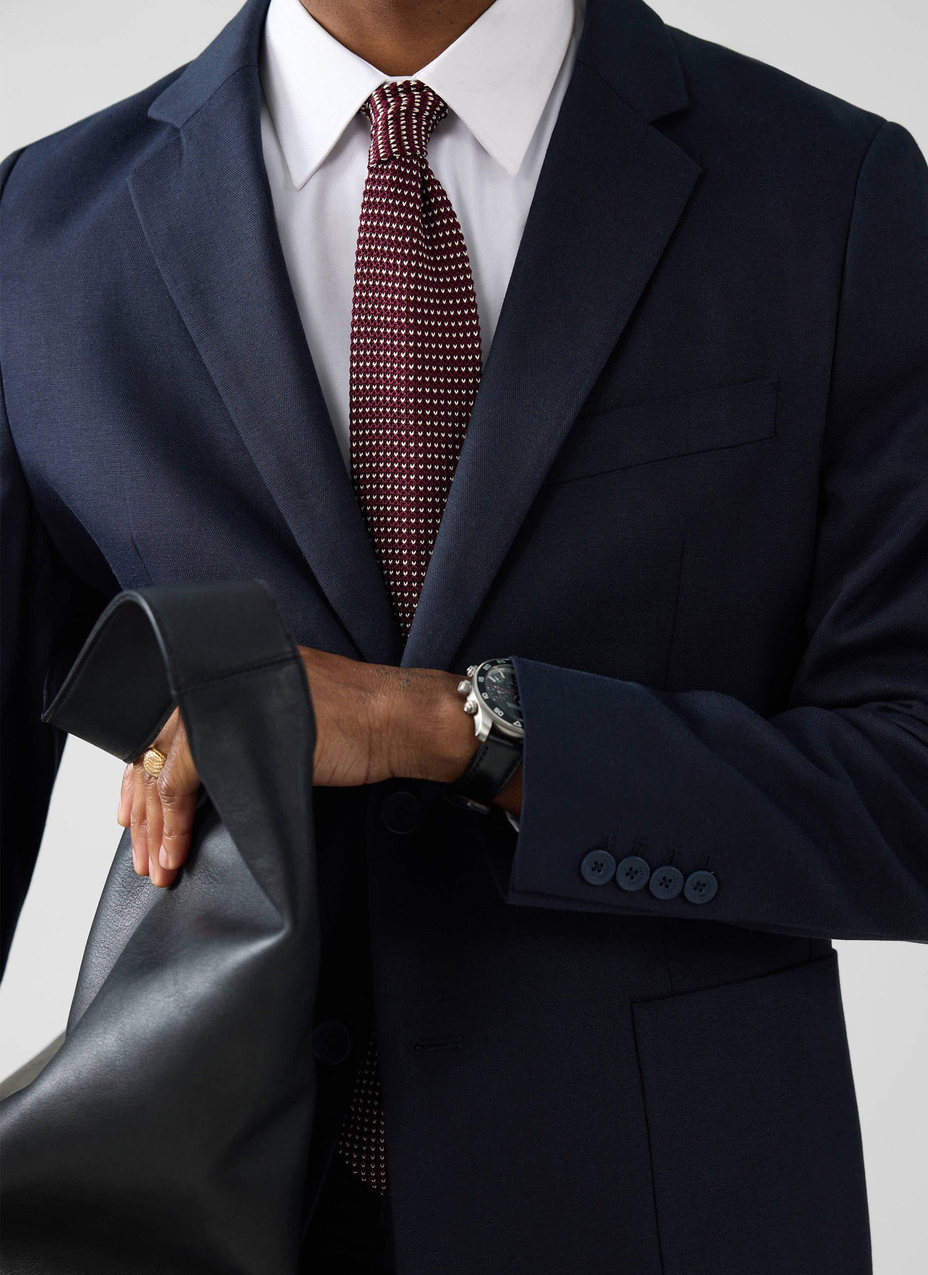 A close-up shot of a model wearing the navy Lyocell Regular Blazer from Percival with a white shirt and patterned tie.