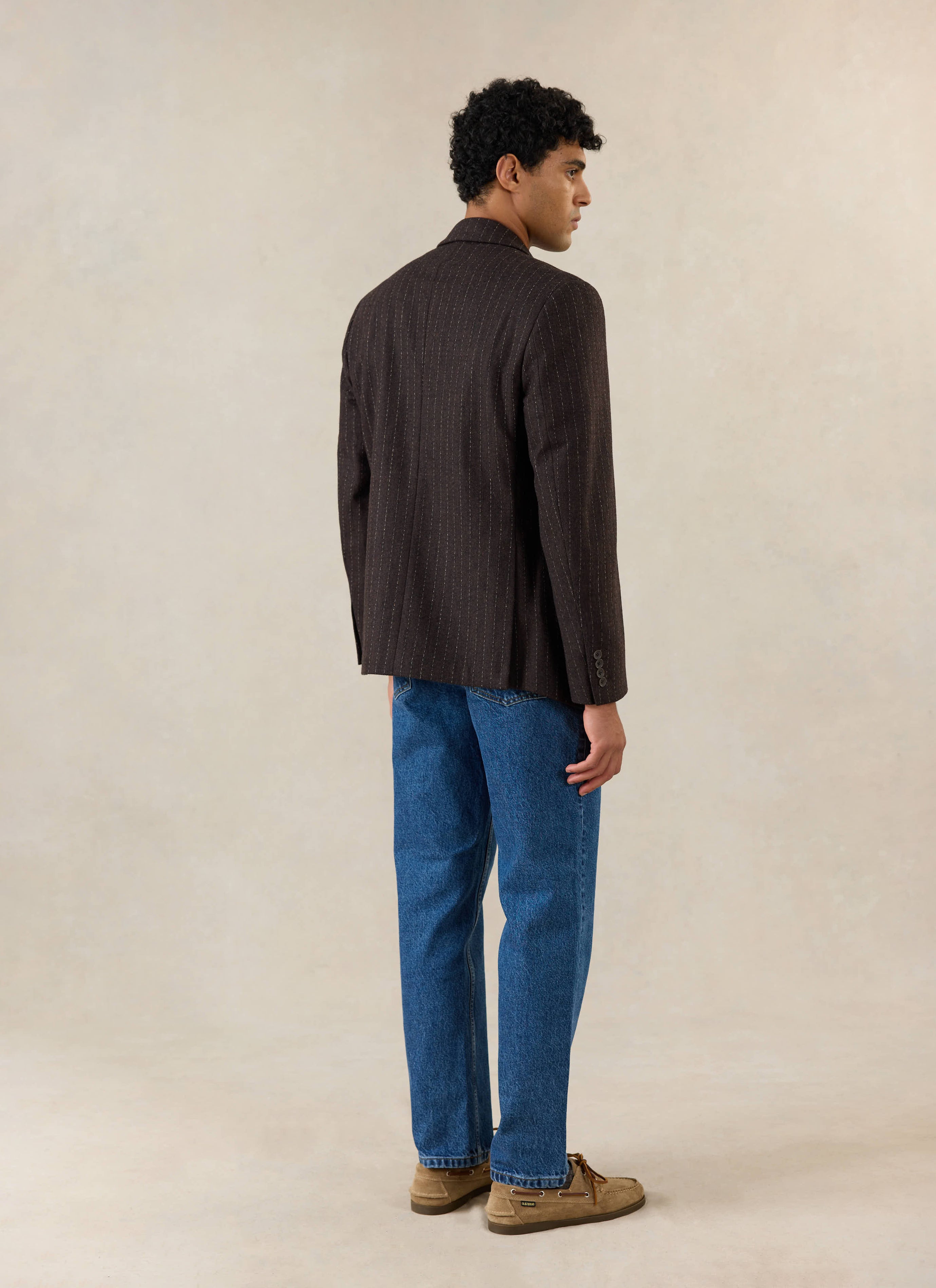 A model wears the Percival Clifton Pinstripe Double Breasted Blazer in espresso, shown from the rear in a studio shot.