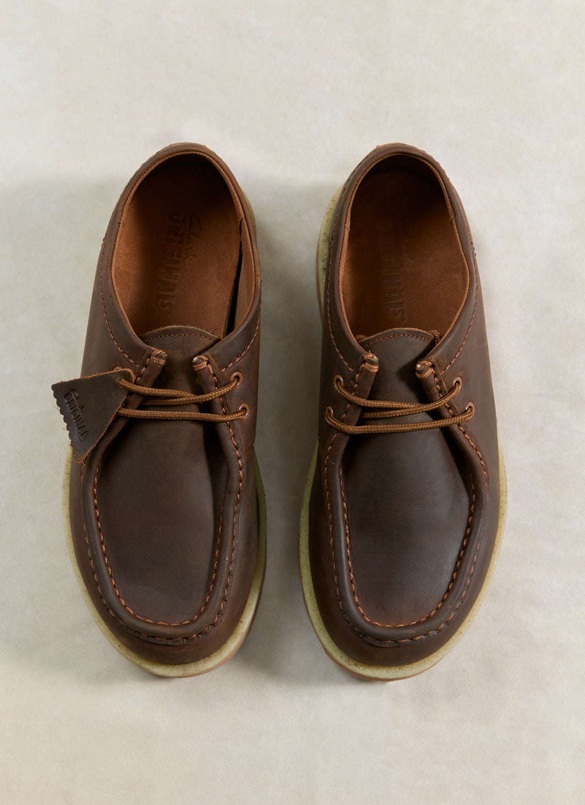 Top-down view of Clarks Originals Meare Walla Shoes in beeswax brown leather, featuring distinct stitching and crepe soles.