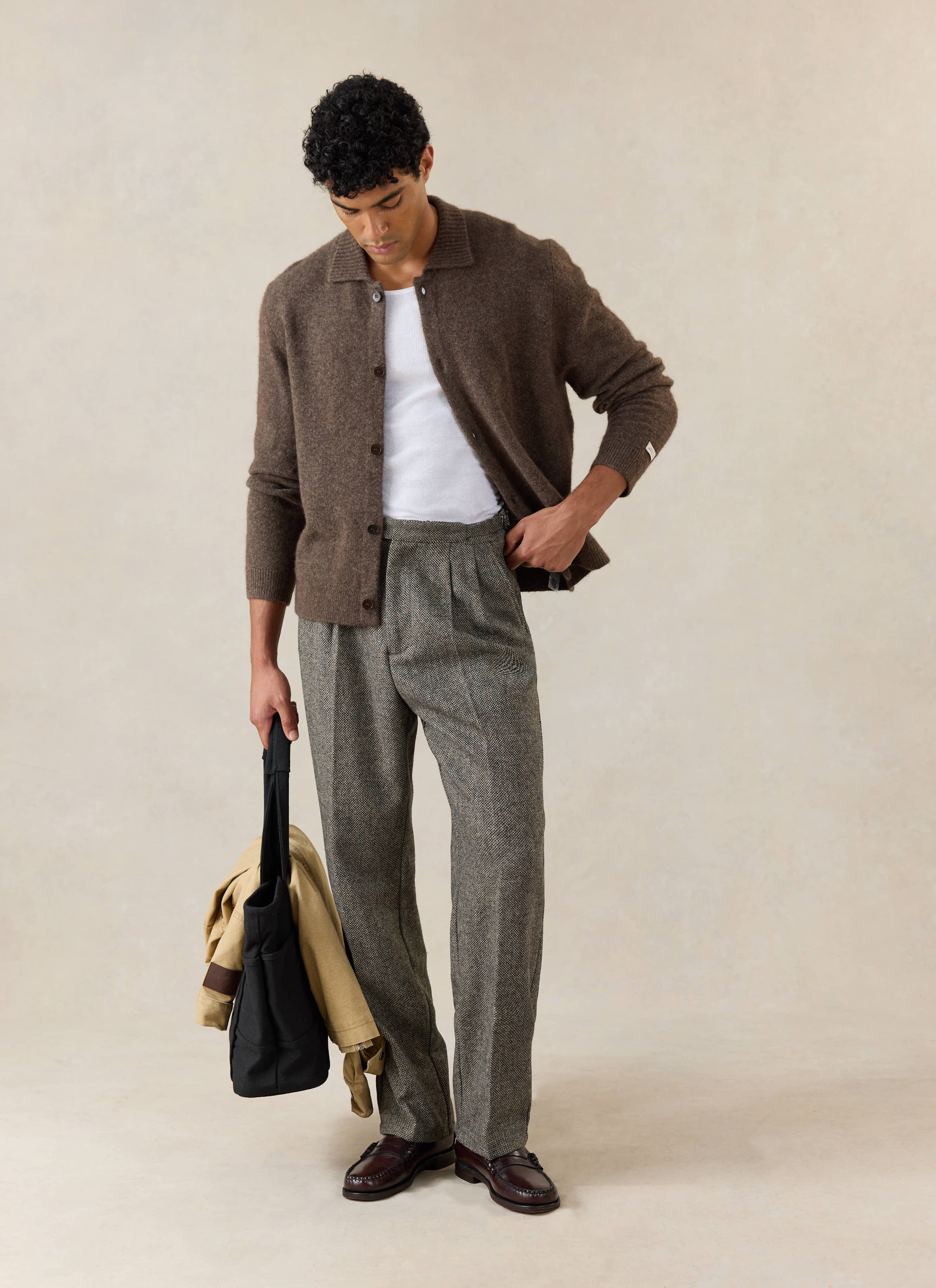 Model wears the brown Percival Archive Collared Cardigan, with a white tank top and grey trousers.