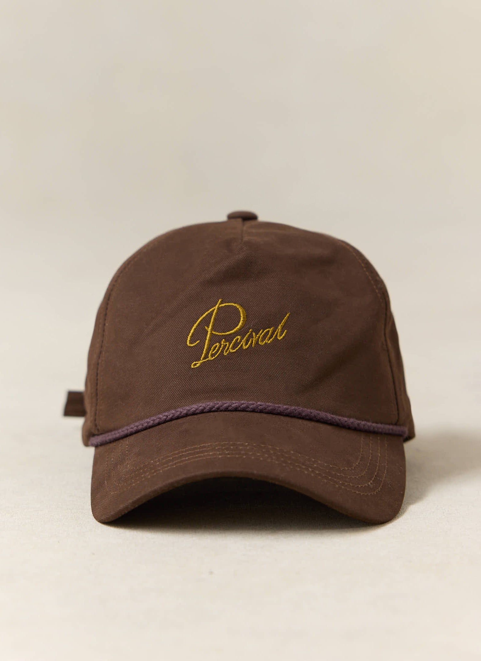 Espresso brown Percival Luther Soft Trucker Cap in brushed cotton featuring gold script embroidery and a front rope detail.
