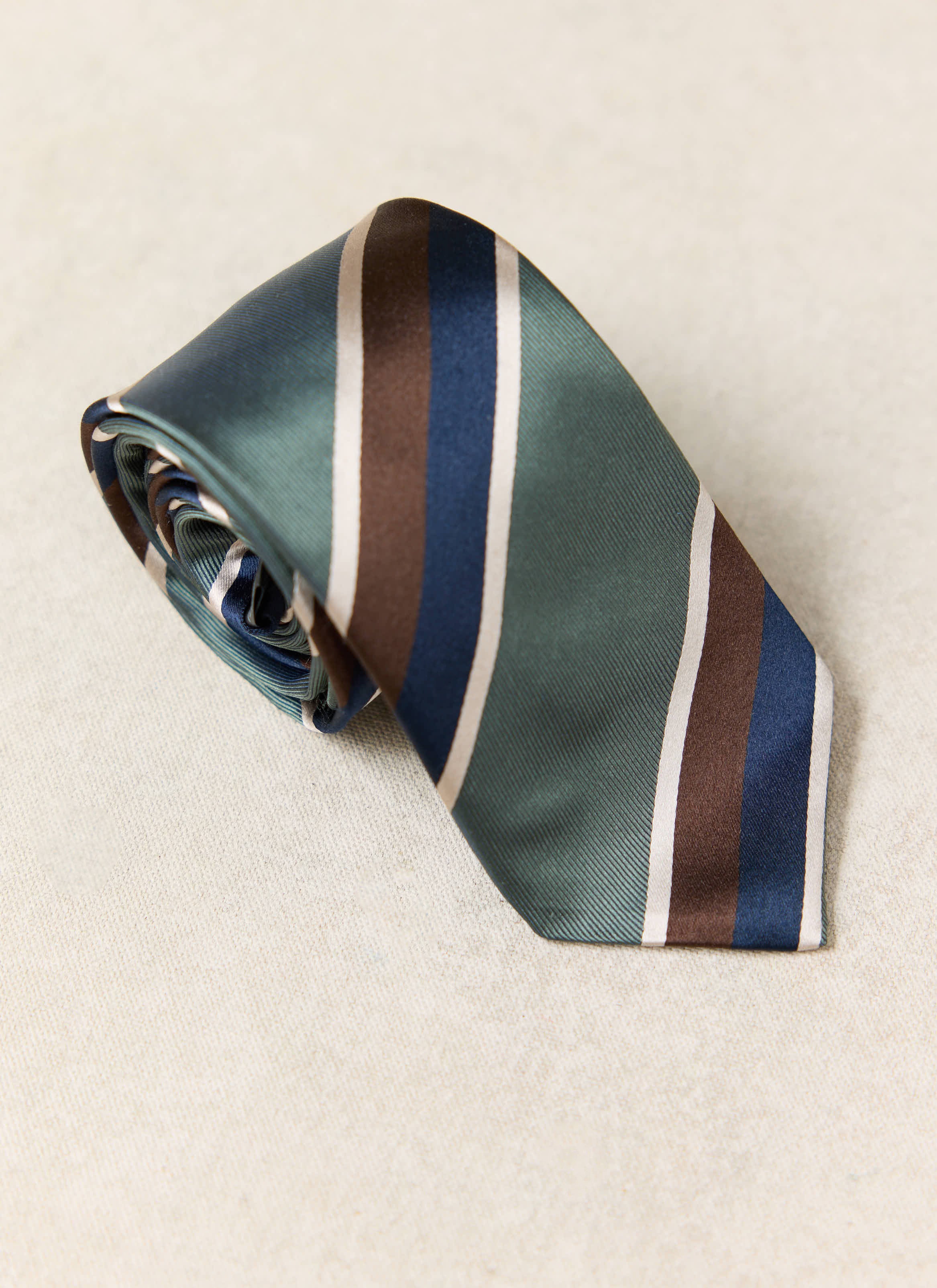 Multi, featuring forest green, navy, brown and cream diagonal stripes, shown rolled up.