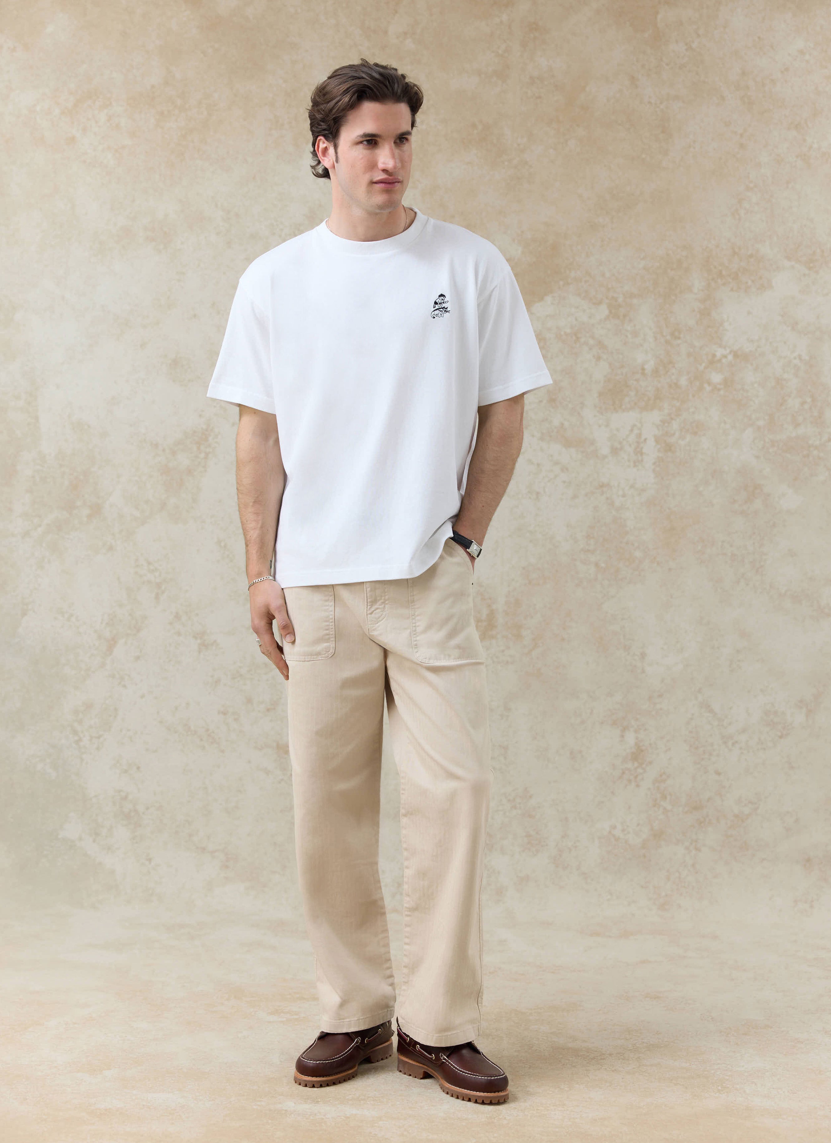 White Percival Palmer organic cotton t-shirt with chest embroidery, styled with beige trousers from the SS26 collection.