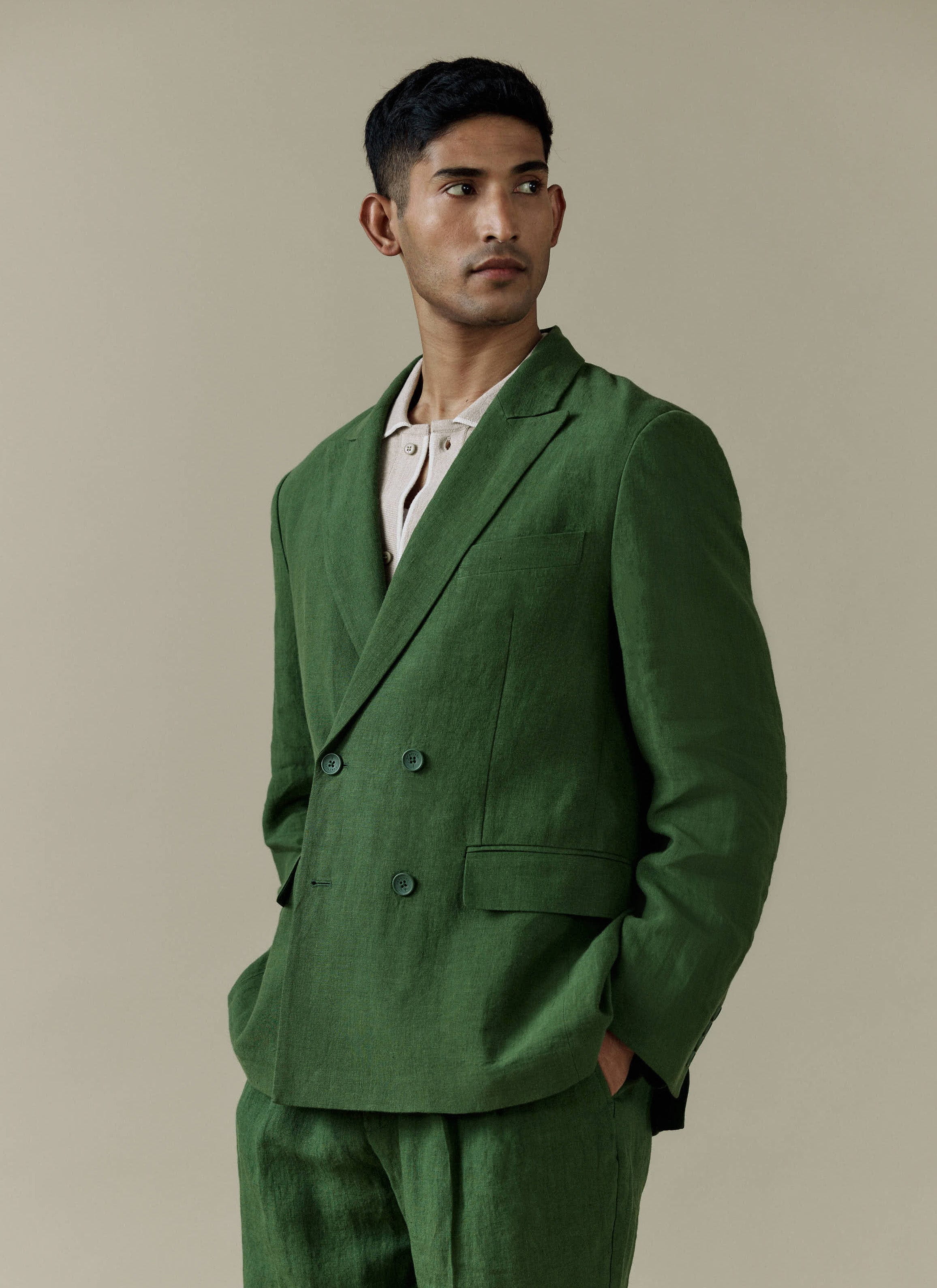 Forest green linen Percival Clifton Double Breasted Blazer and matching trousers, styled with a light cream polo shirt.