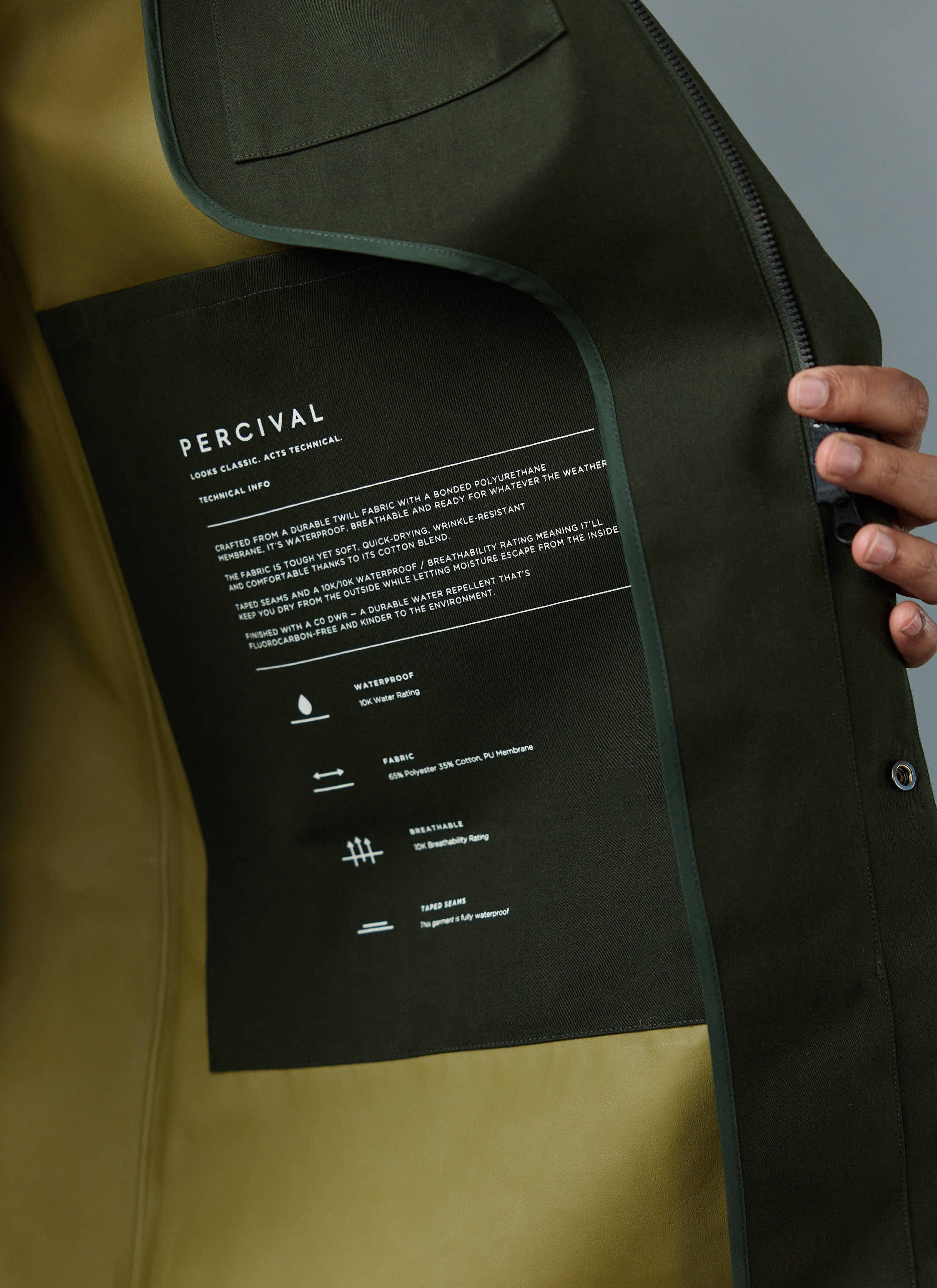 A detailed close-up of the technical information label inside the forest green waterproof Greyson Trench Coat by Percival.