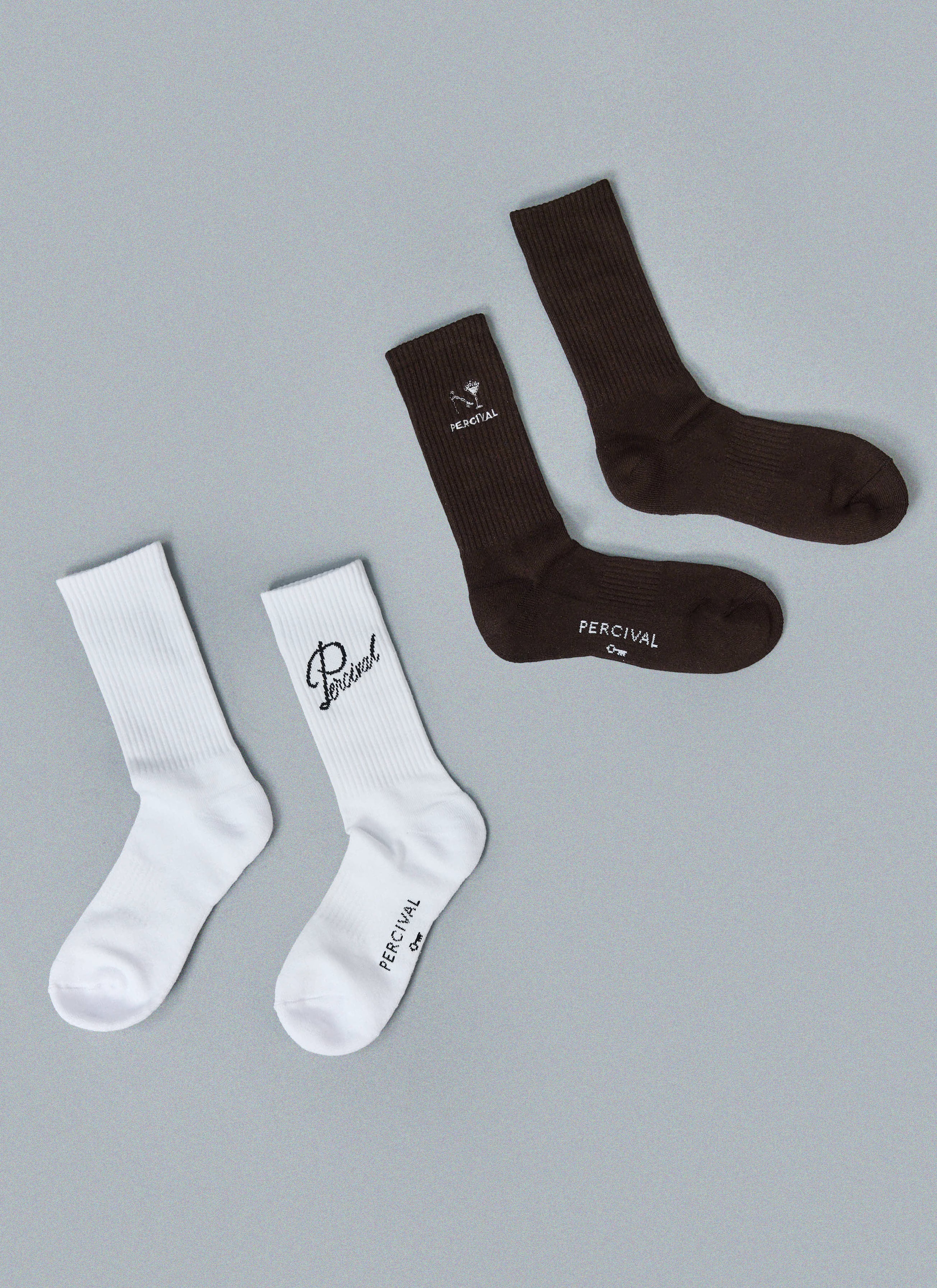 Percival black and white crew socks featuring aperitivo and script embroidery, shown flat against a grey background.