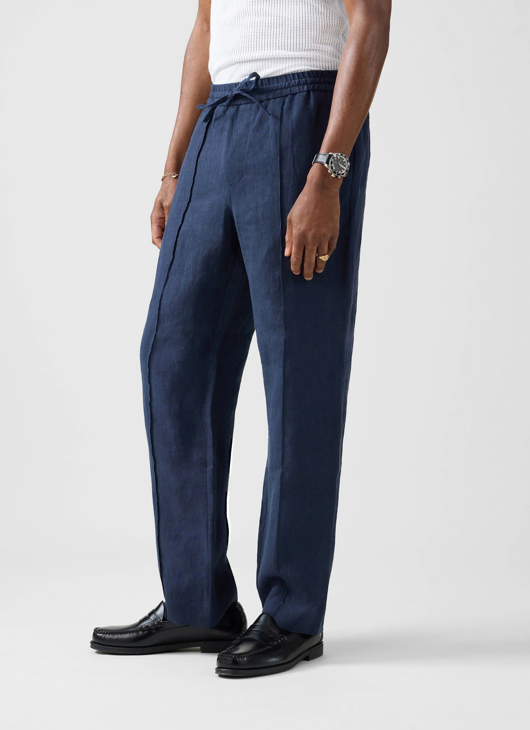 A model wears the Lorena Wide Leg Trousers in navy linen by Percival, showing the relaxed fit and drawstring waist detail.