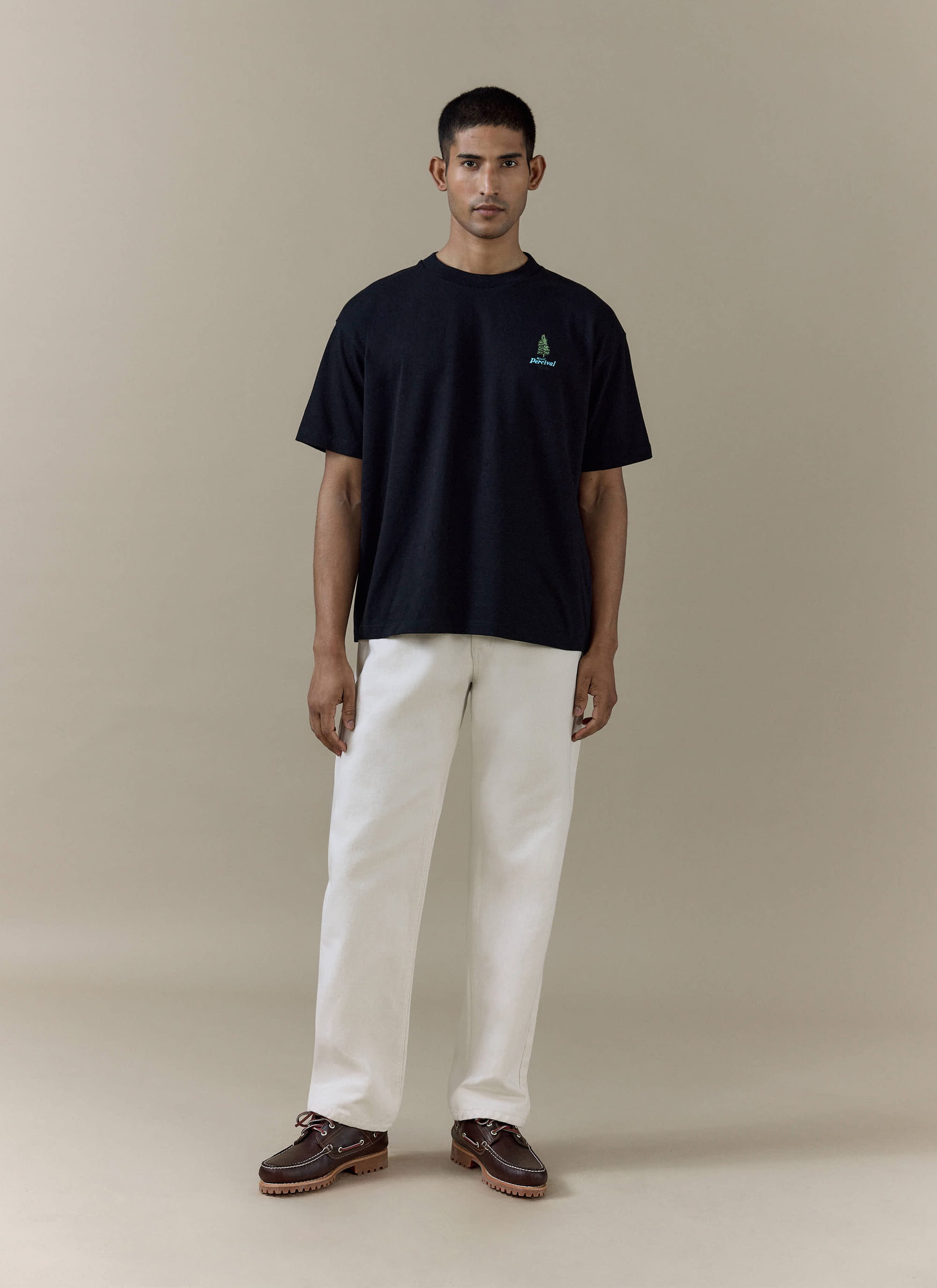 Black organic cotton Arnold Oversized T Shirt by Percival, featuring a small green tree chest graphic on a model.