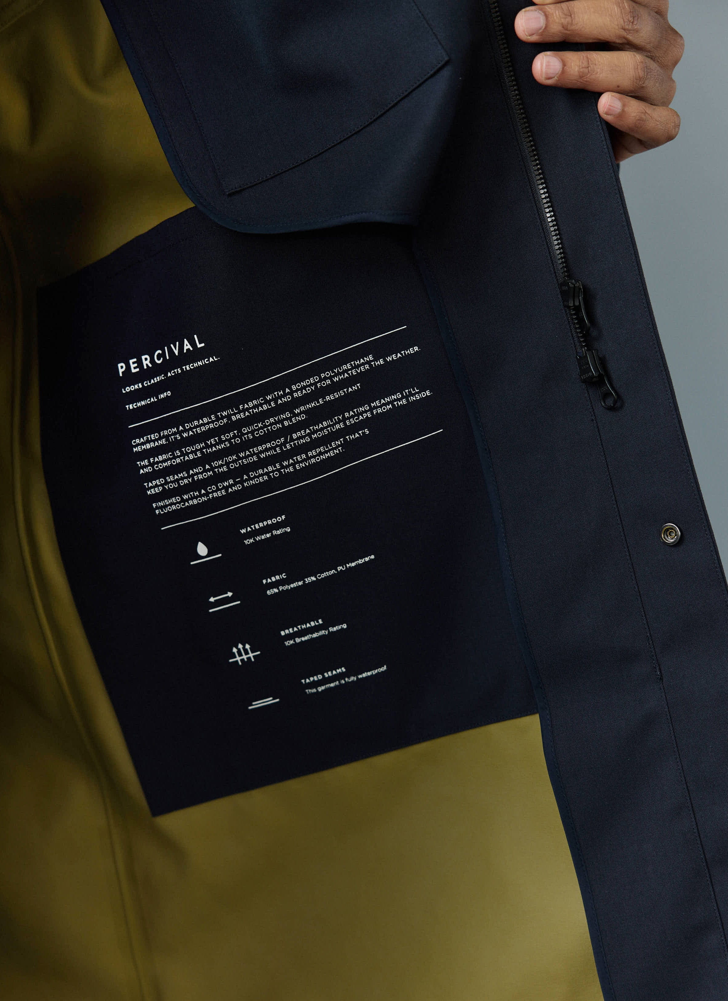 Close-up of the technical information label inside the navy and olive Percival Greyson Waterproof Trench Coat.