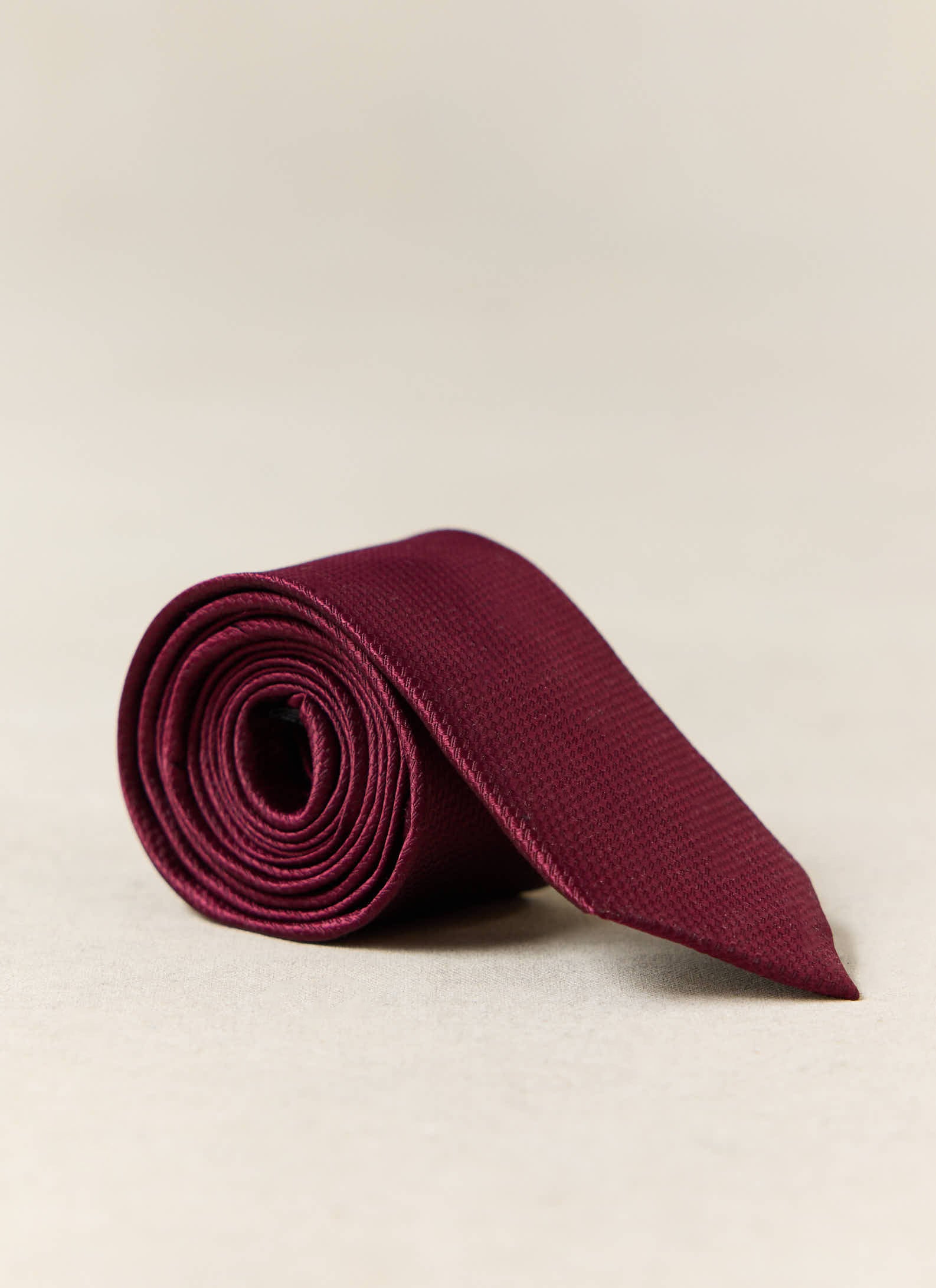 Percival Red Silk Grenadine Tie, neatly rolled to show its classic textured weave.