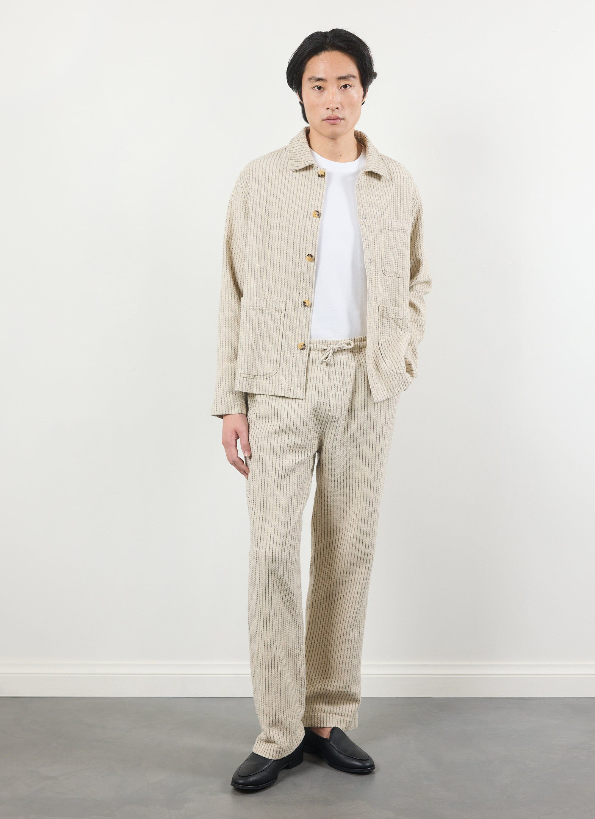 A model wears the Percival Sorrento Trousers and matching jacket in ecru, a striped cotton and linen blend co-ord.