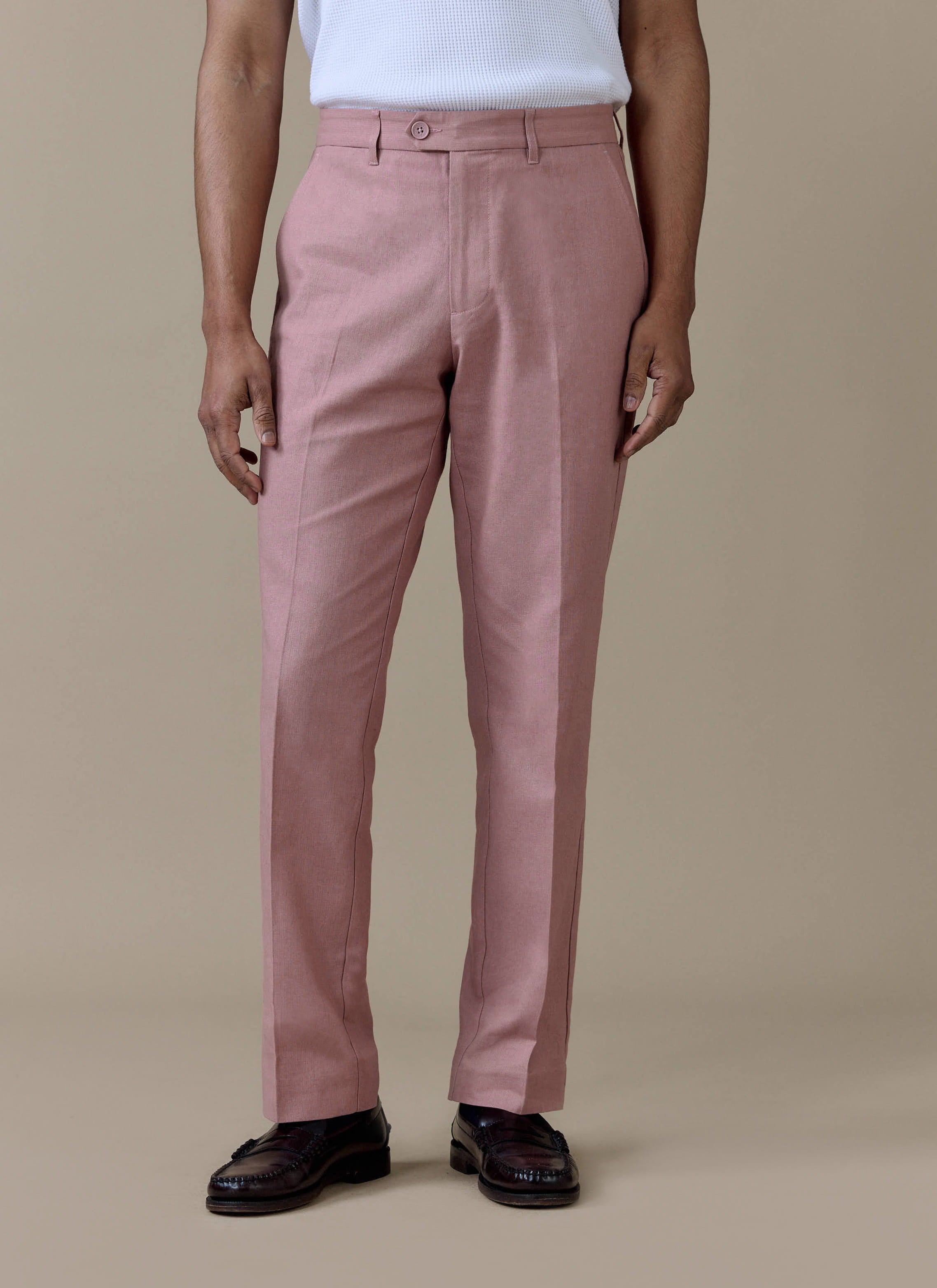 Tailored dusty pink linen trousers by Percival, featuring a sharp centre crease and straight leg fit.