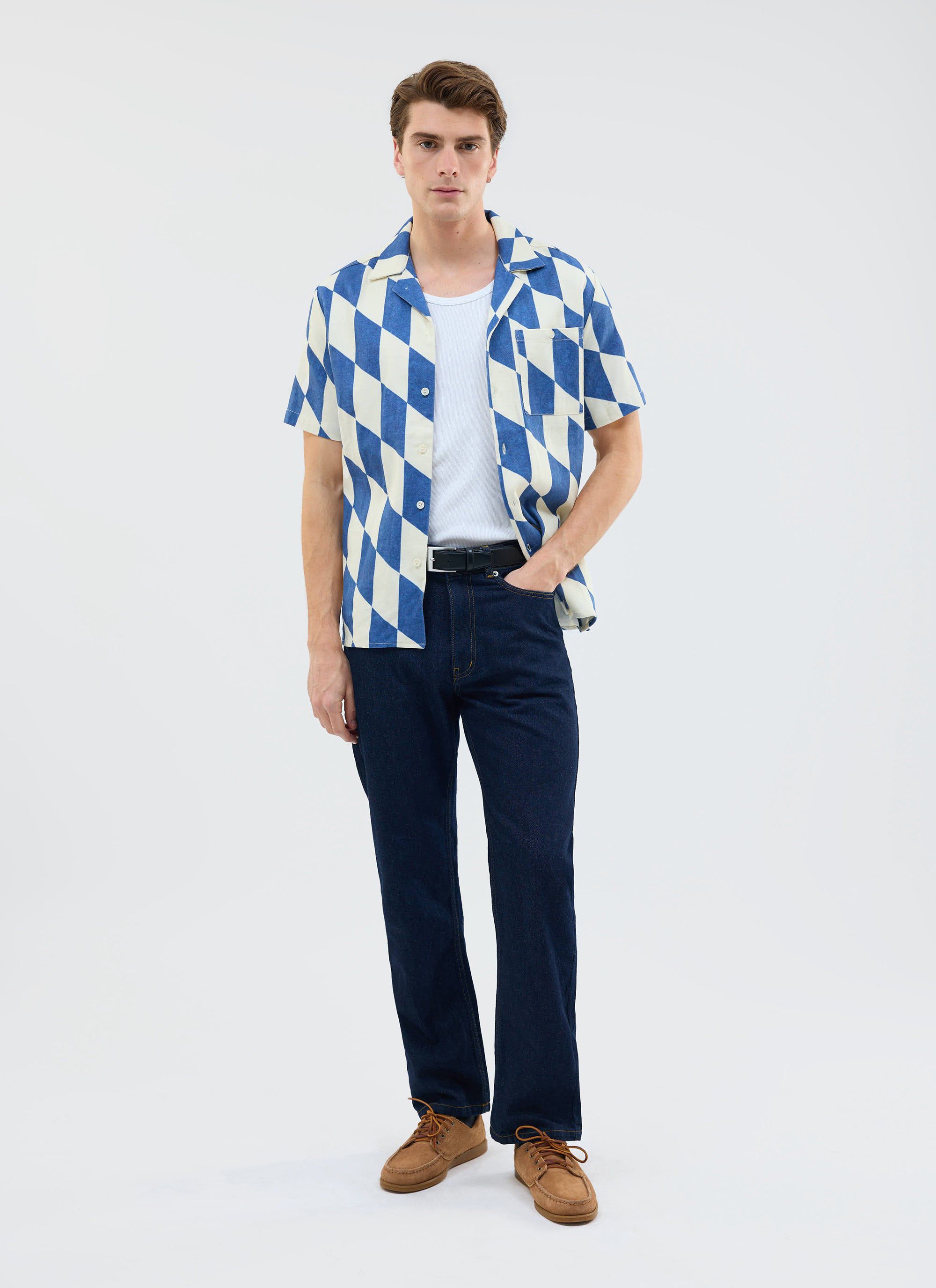 A model wears the Percival Market Diamond Cuban Shirt in ecru and navy, styled with dark jeans and a white t-shirt.