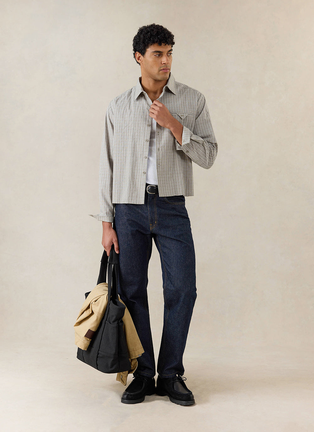 A model wears the cream check Percival Hinsley shirt in 100% cotton, styled with dark jeans and a black tote bag.