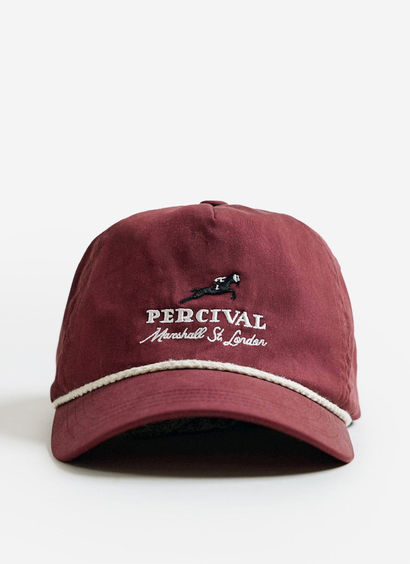 The red cotton Tournament Soft Trucker Cap by Percival, featuring white embroidery and rope detail at the brim.