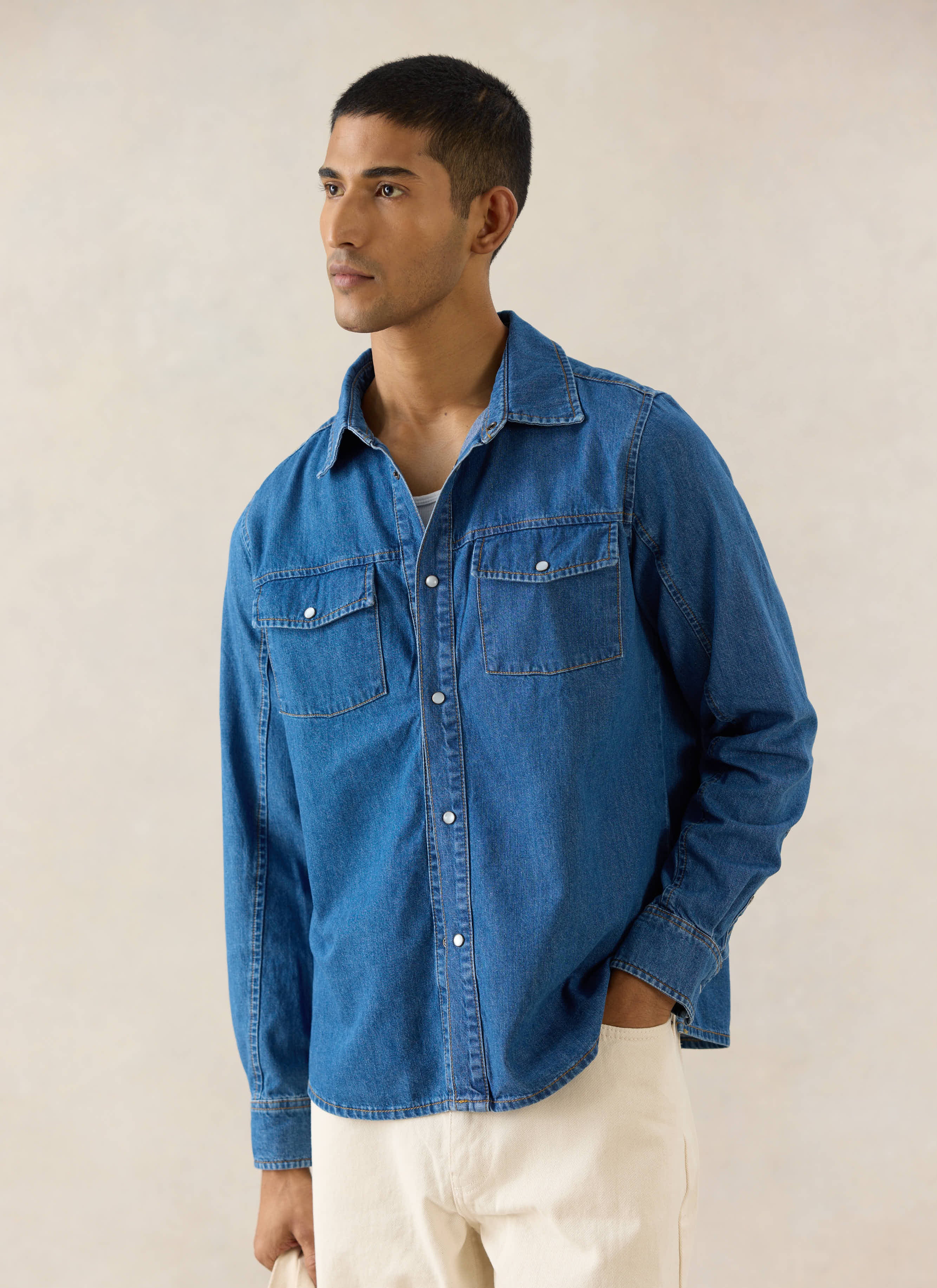 Percival mid wash blue denim Western shirt featuring pearl buttons and chest pockets, shown on a model.