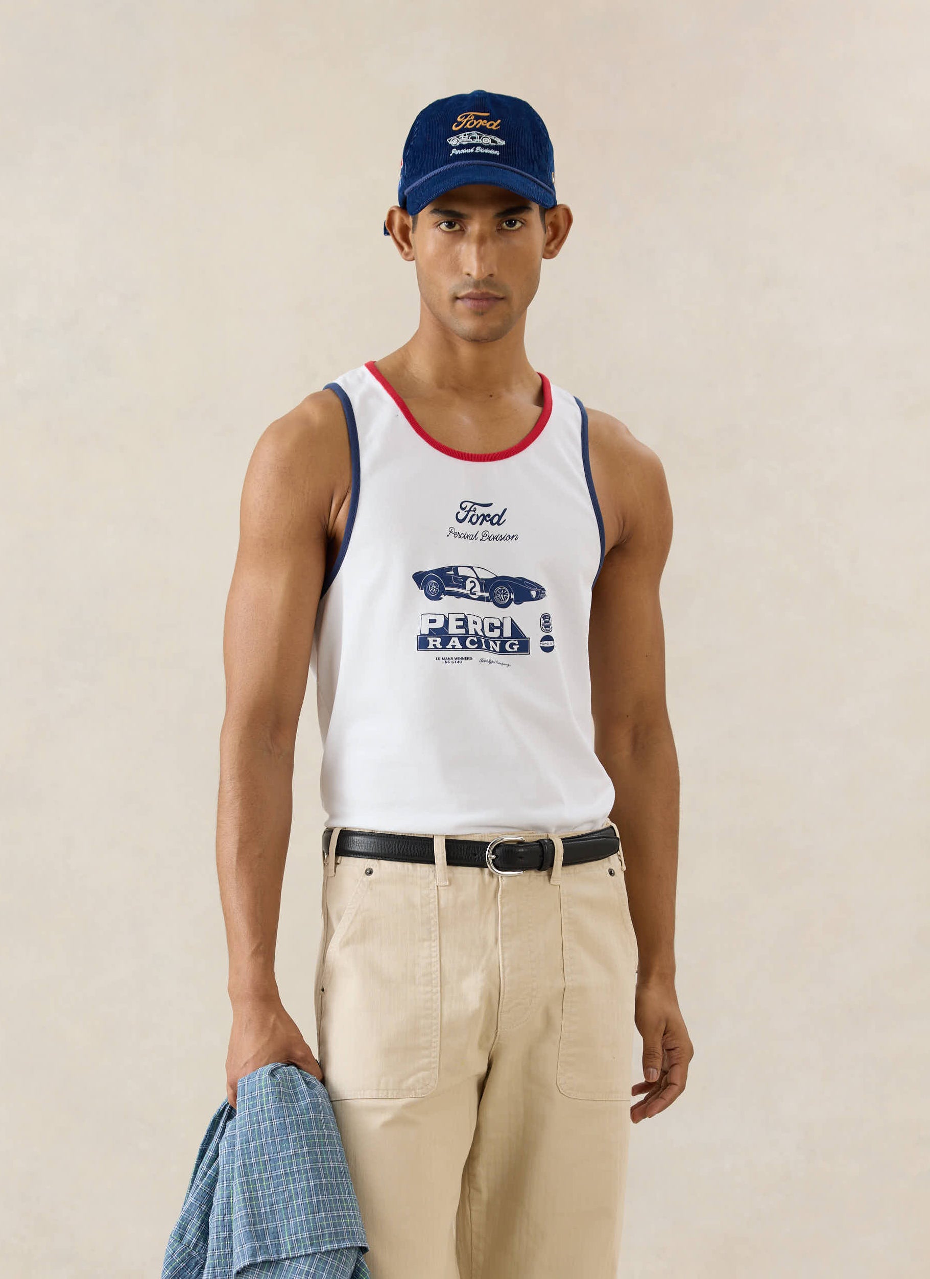 White Ford x Percival GT40 ringer vest in organic cotton, styled with beige workwear trousers and a navy cord cap.