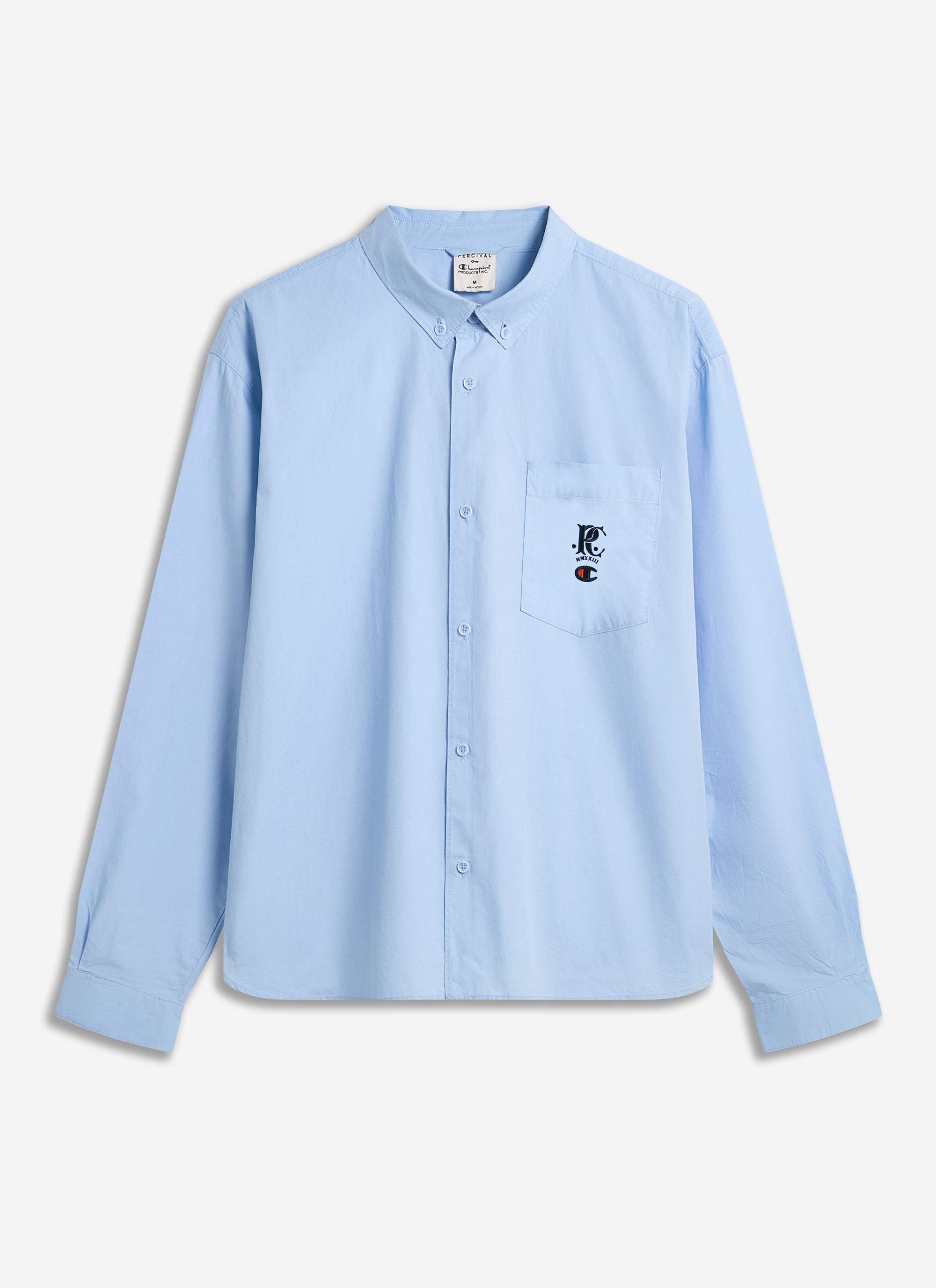 The Champion x Percival relaxed oxford shirt in dusty blue, pictured flat to showcase its cut and embroidered pocket logo.