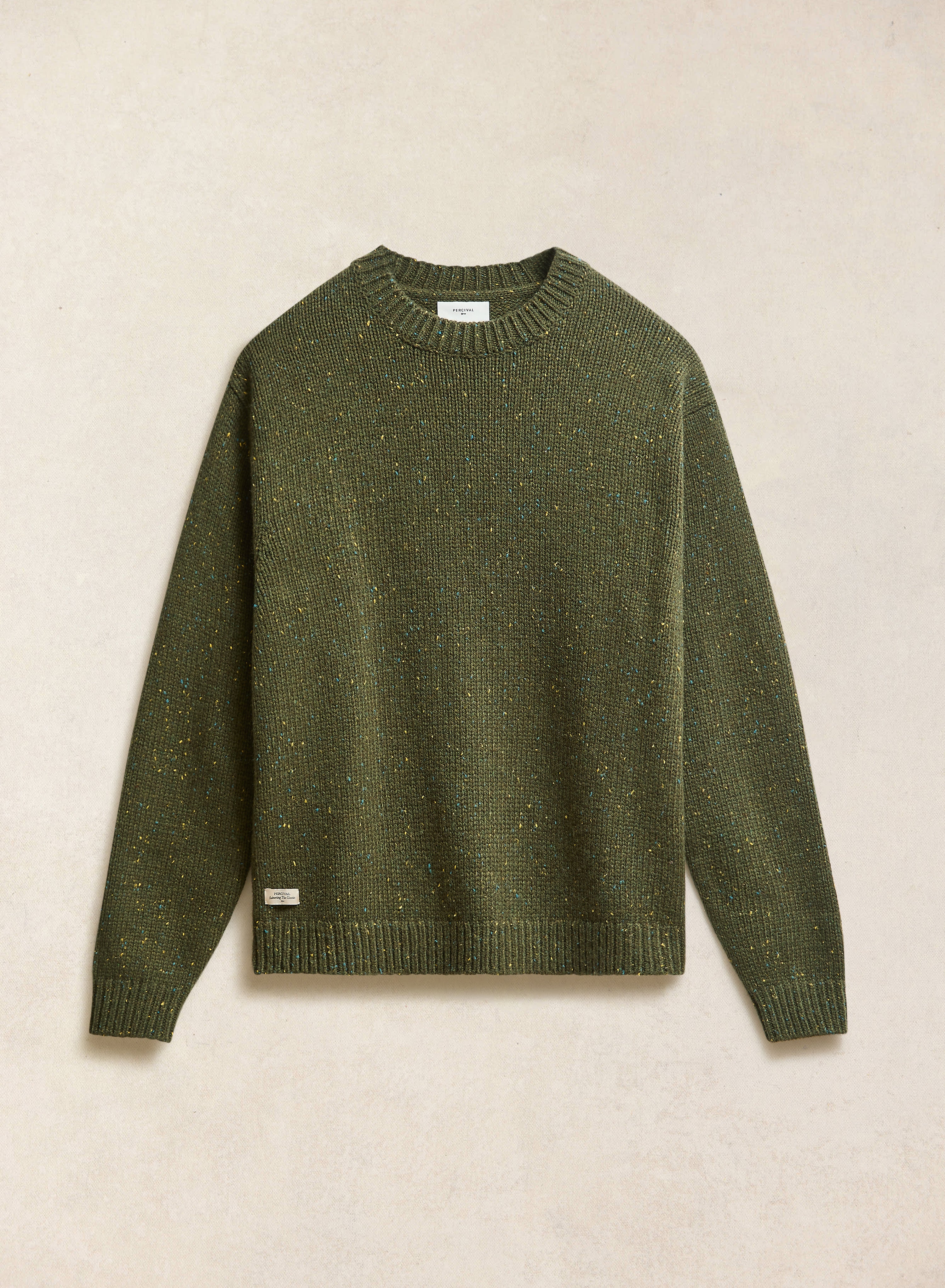 A forest green speckled Rhodes crew neck jumper from Percival, laid flat to show the textured knit and ribbed trims.