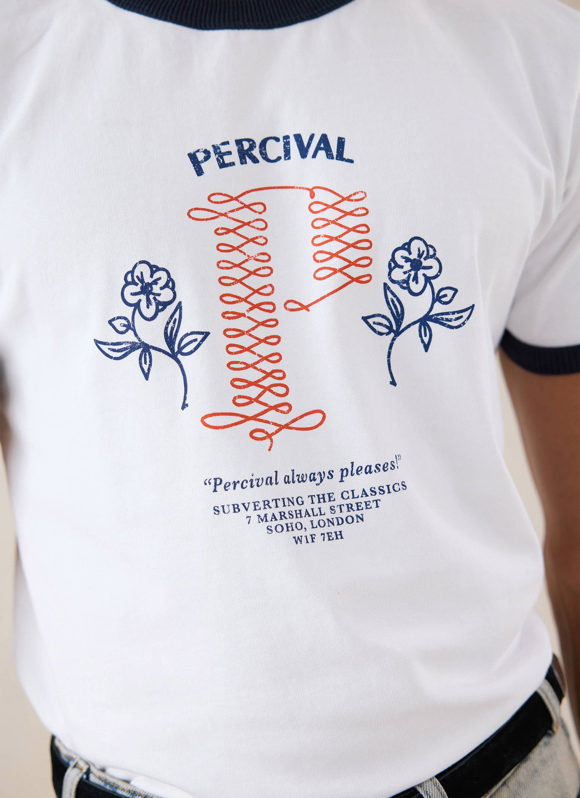 Close-up of a model wearing the white Tucker Ringer T-Shirt from Percival, highlighting the graphic chest print.