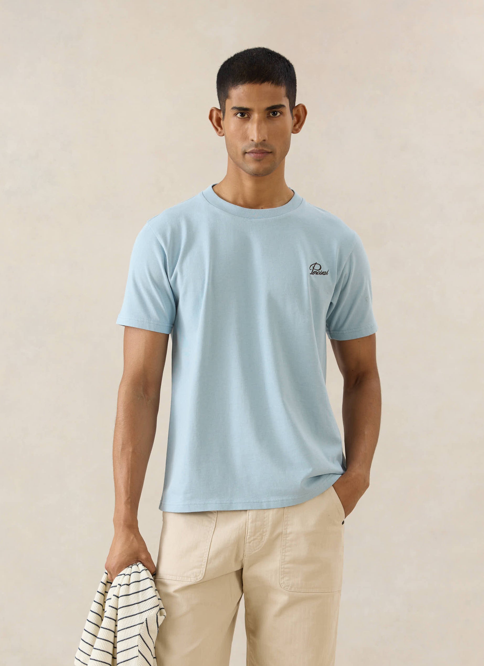 The Percival Perci Script t-shirt in light blue organic cotton, styled with the Lucas carpenter trousers in beige.