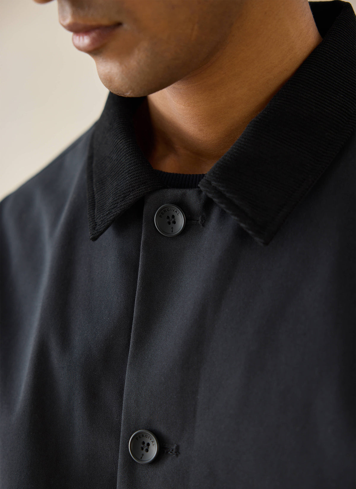 Close-up view of a model wearing the black Percival Sherlock Short Trench Coat, highlighting the collar and buttons.