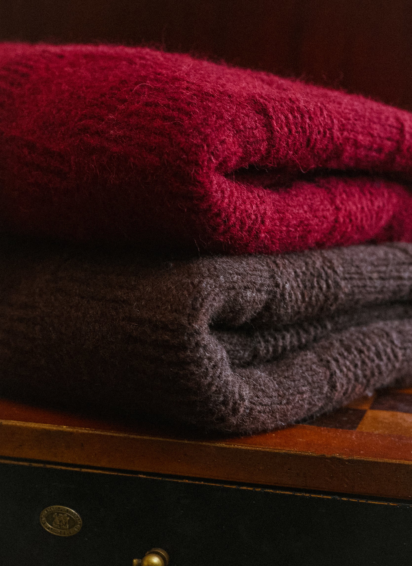 Folded Percival Shugart knit jumpers in burgundy and dark brown, showcasing the soft alpaca and wool blend texture.