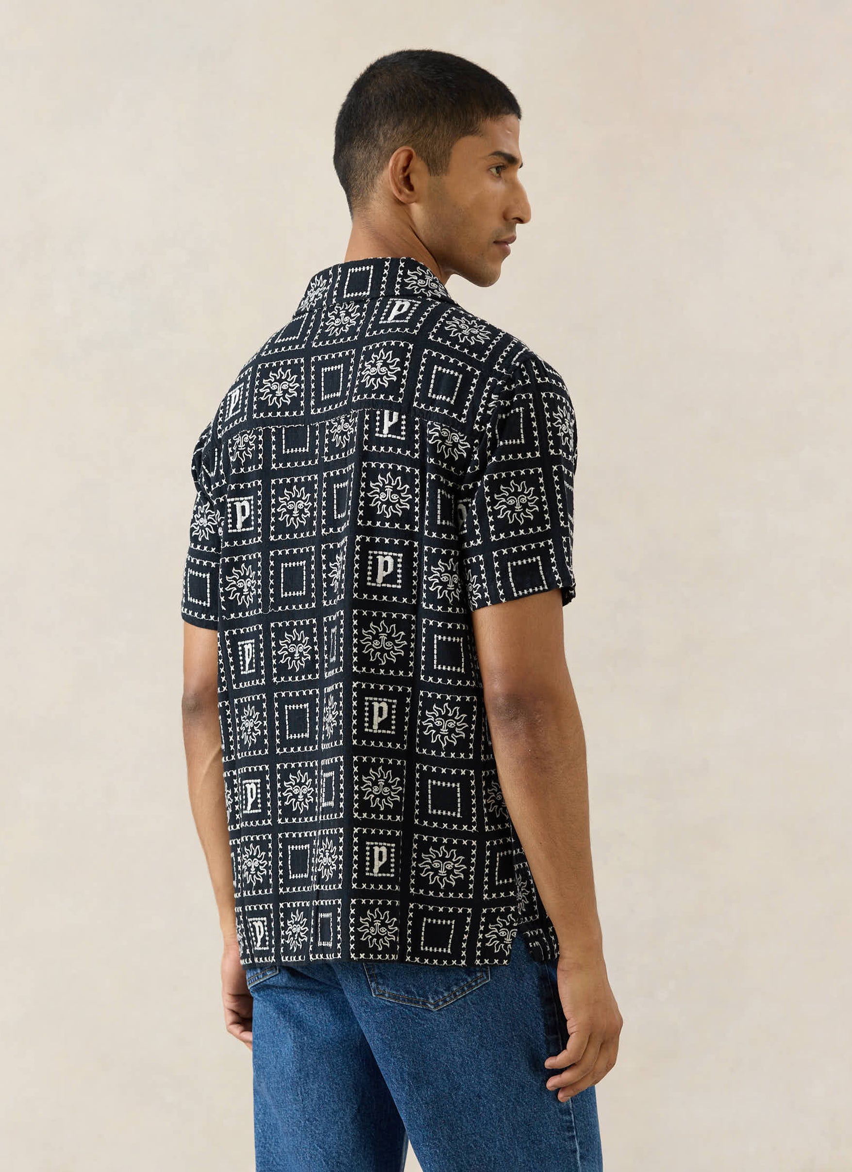 Black Percival Solis Heaton Cuban Shirt in a linen blend with a sun motif pattern, shown from the back on a model.