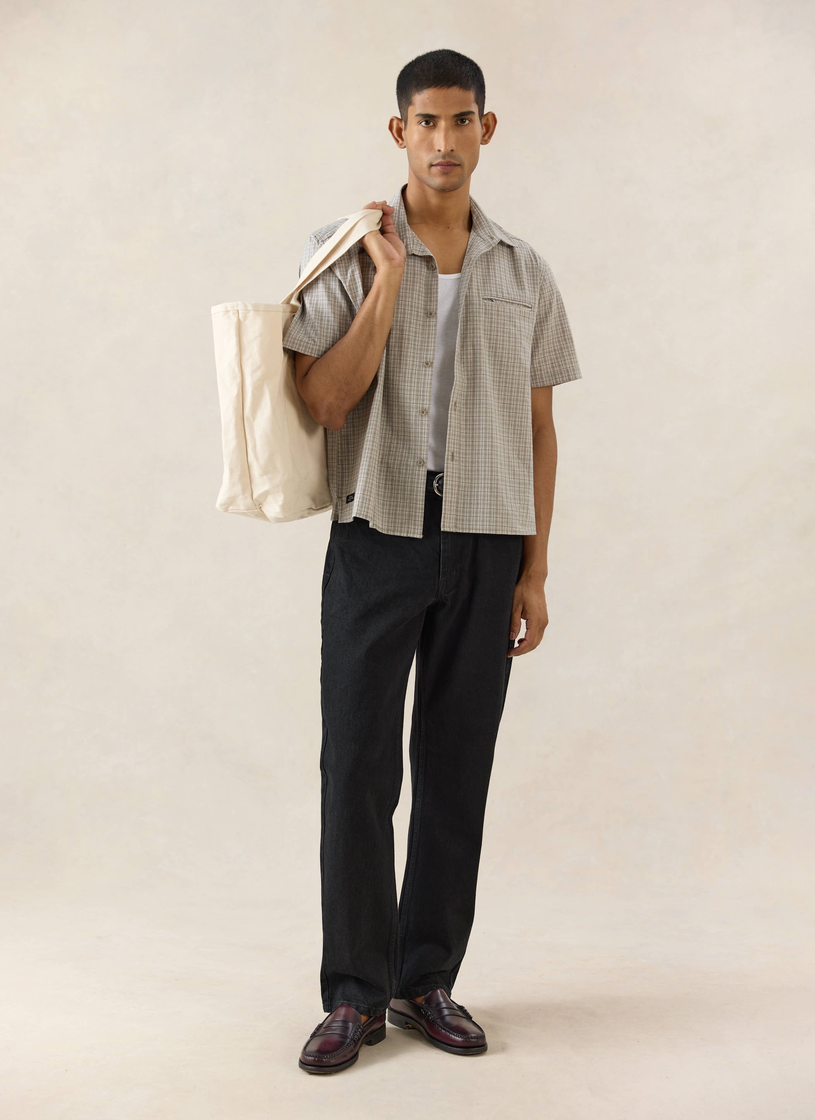 Percival straight leg heritage denim jeans in black cotton, styled with a short sleeve shirt and canvas tote.