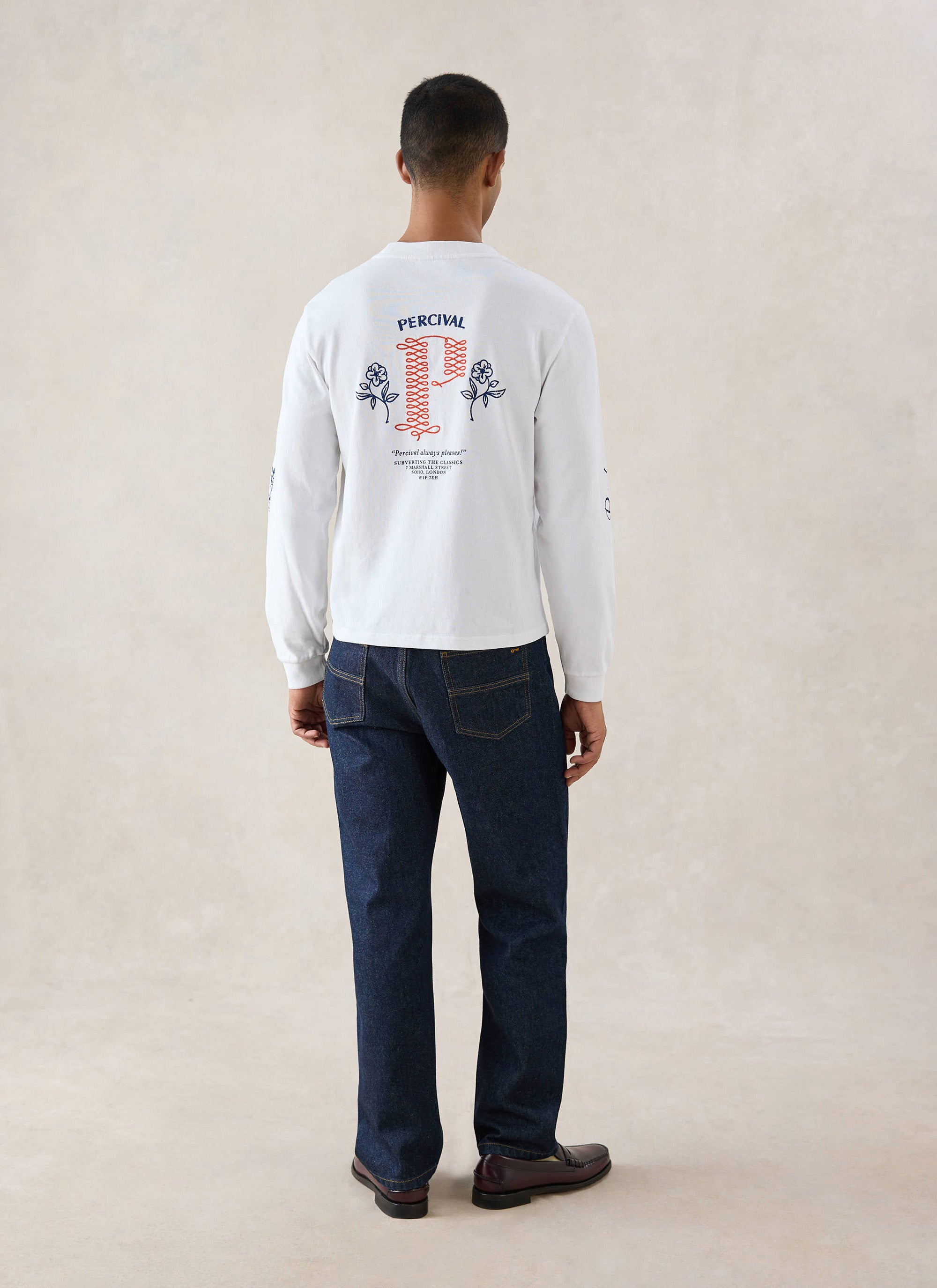 White Percival Tucker long sleeve t-shirt seen from behind on a model, showcasing the large back graphic and blue jeans.