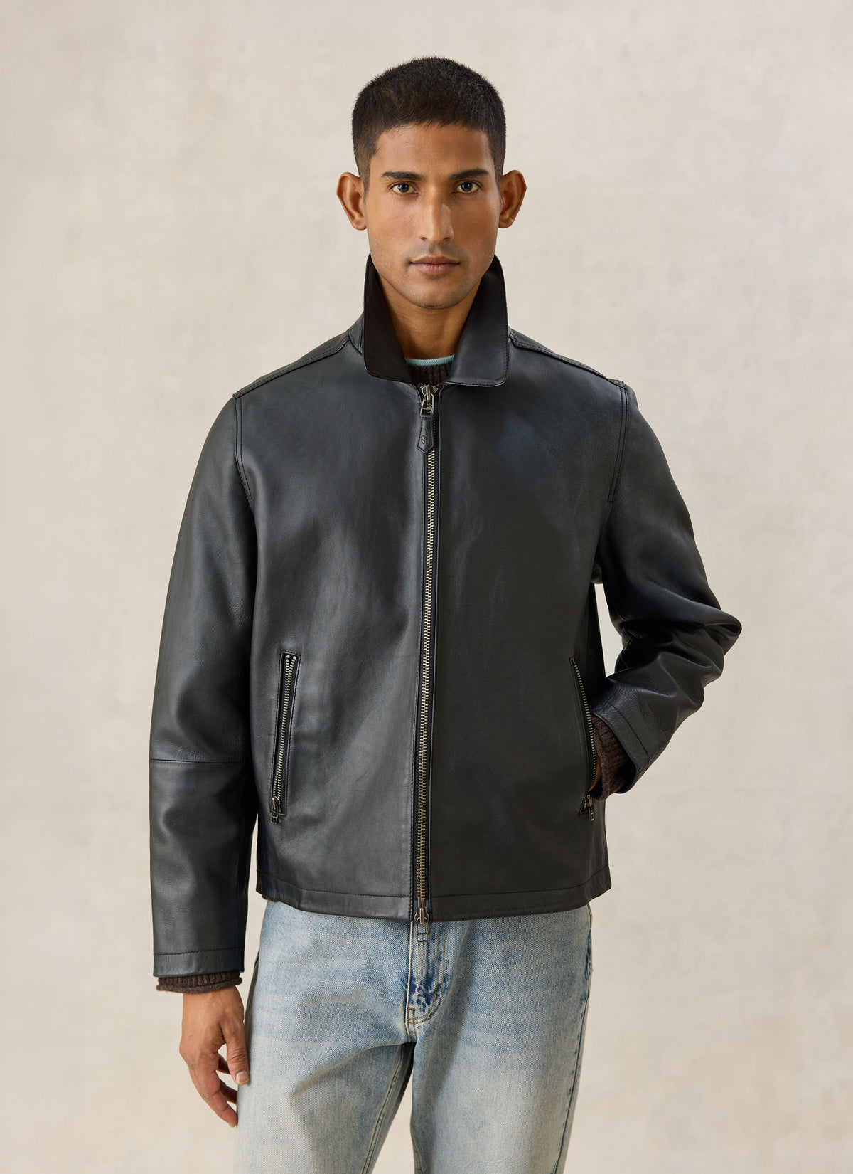 A model wearing the black Percival Turner zip leather jacket in 100% leather with a collar and matching trousers.