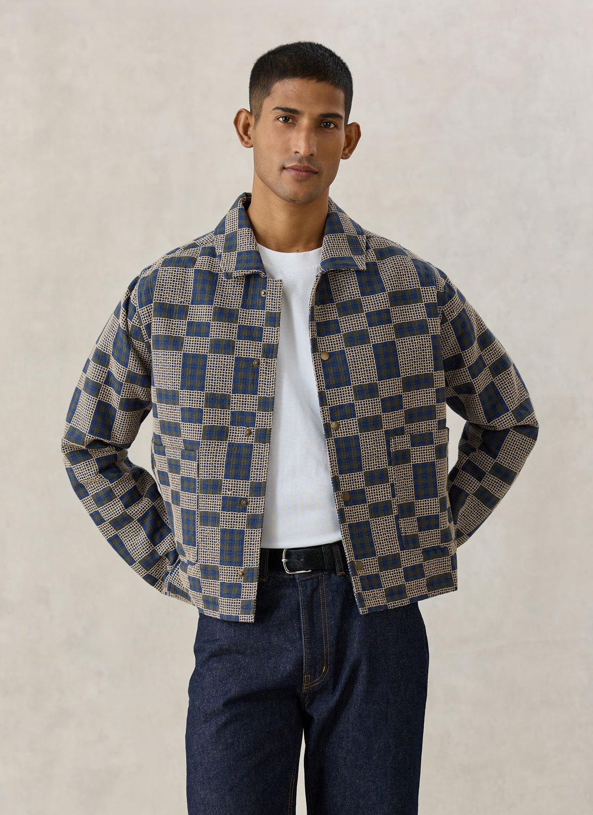 A model wearing the Percival navy blue Wallis grid check overshirt in 100% cotton over a white t-shirt and jeans.