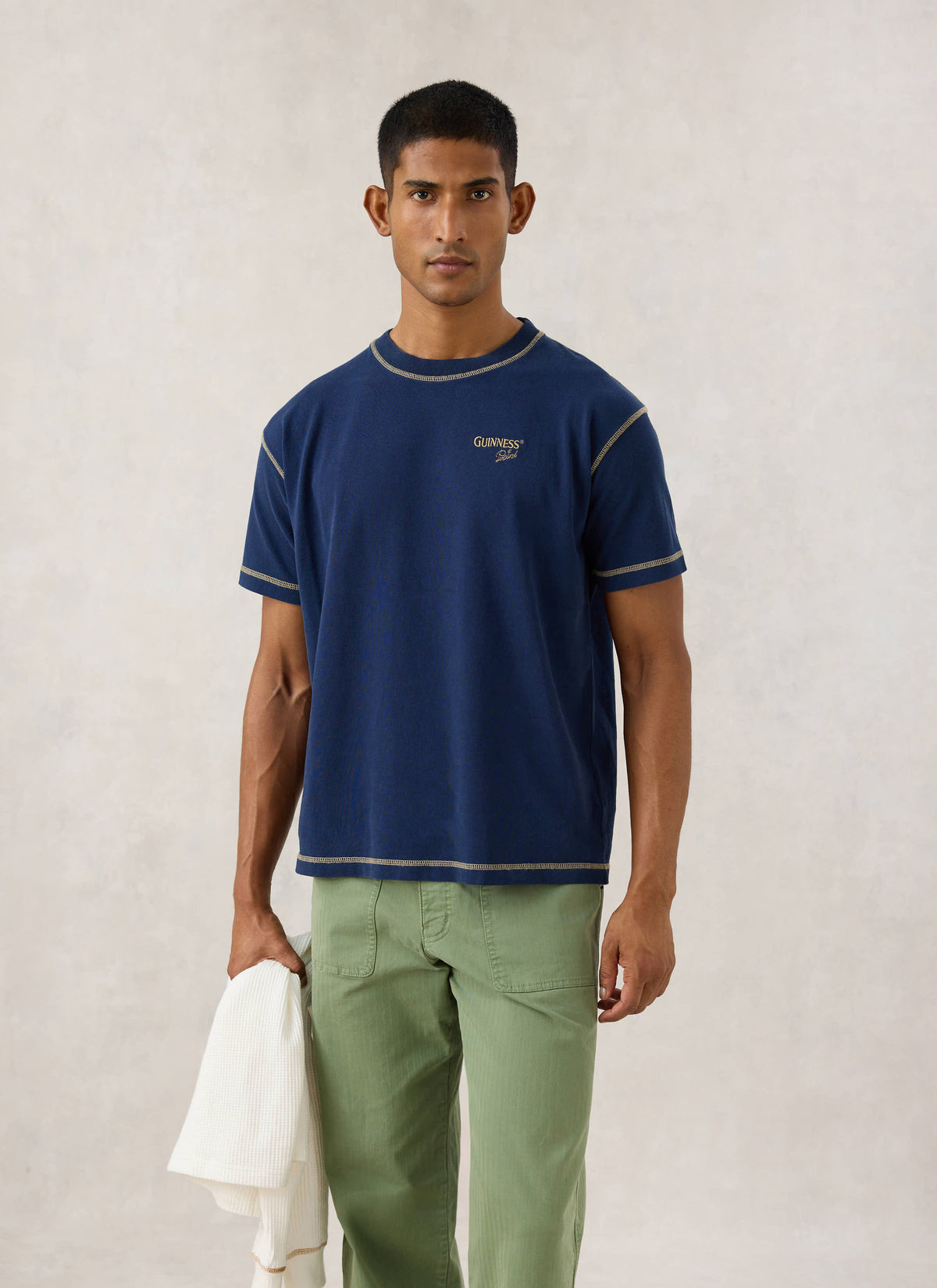 Model wearing the navy Guinness x Percival T-shirt, showing contrast stitching and chest embroidery.