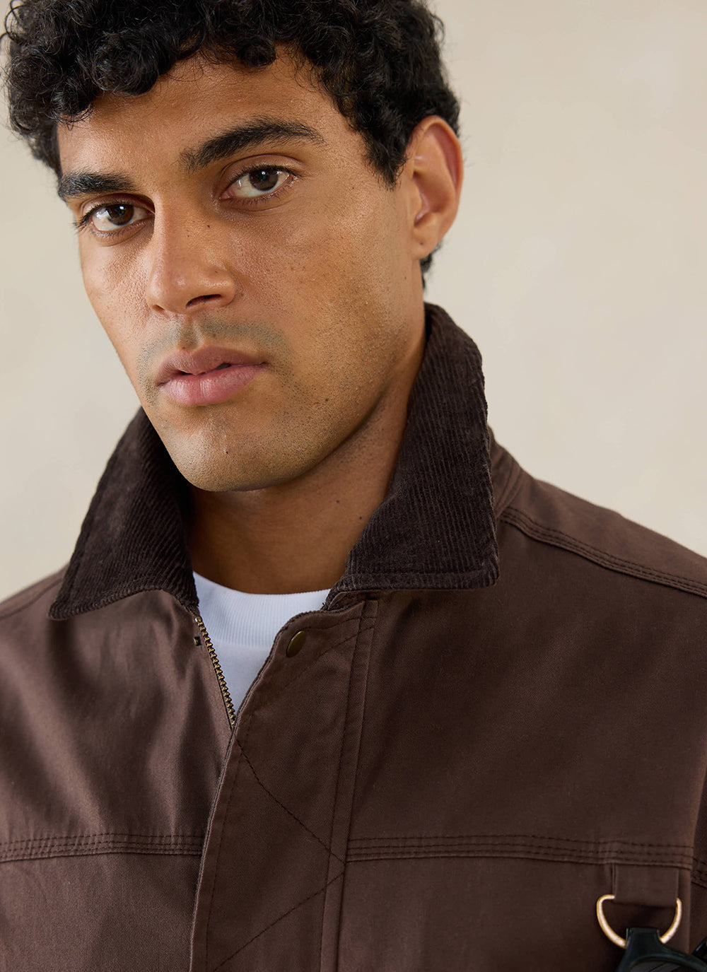 Close-up of a model wearing the Percival espresso brown wax zip jacket with a structured collar.