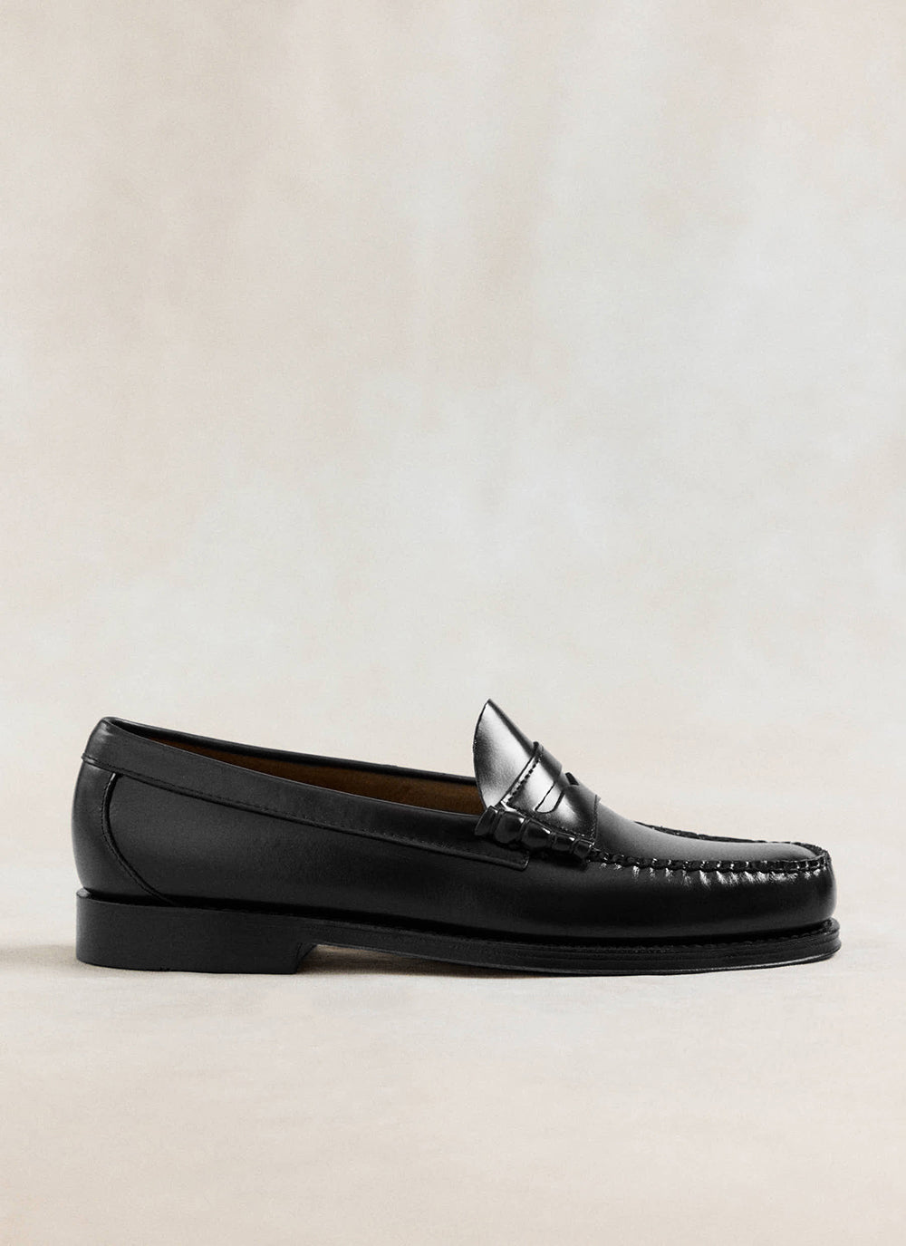 G.H. Bass black polished leather Weejun Larson penny loafer shown in profile against a neutral background.