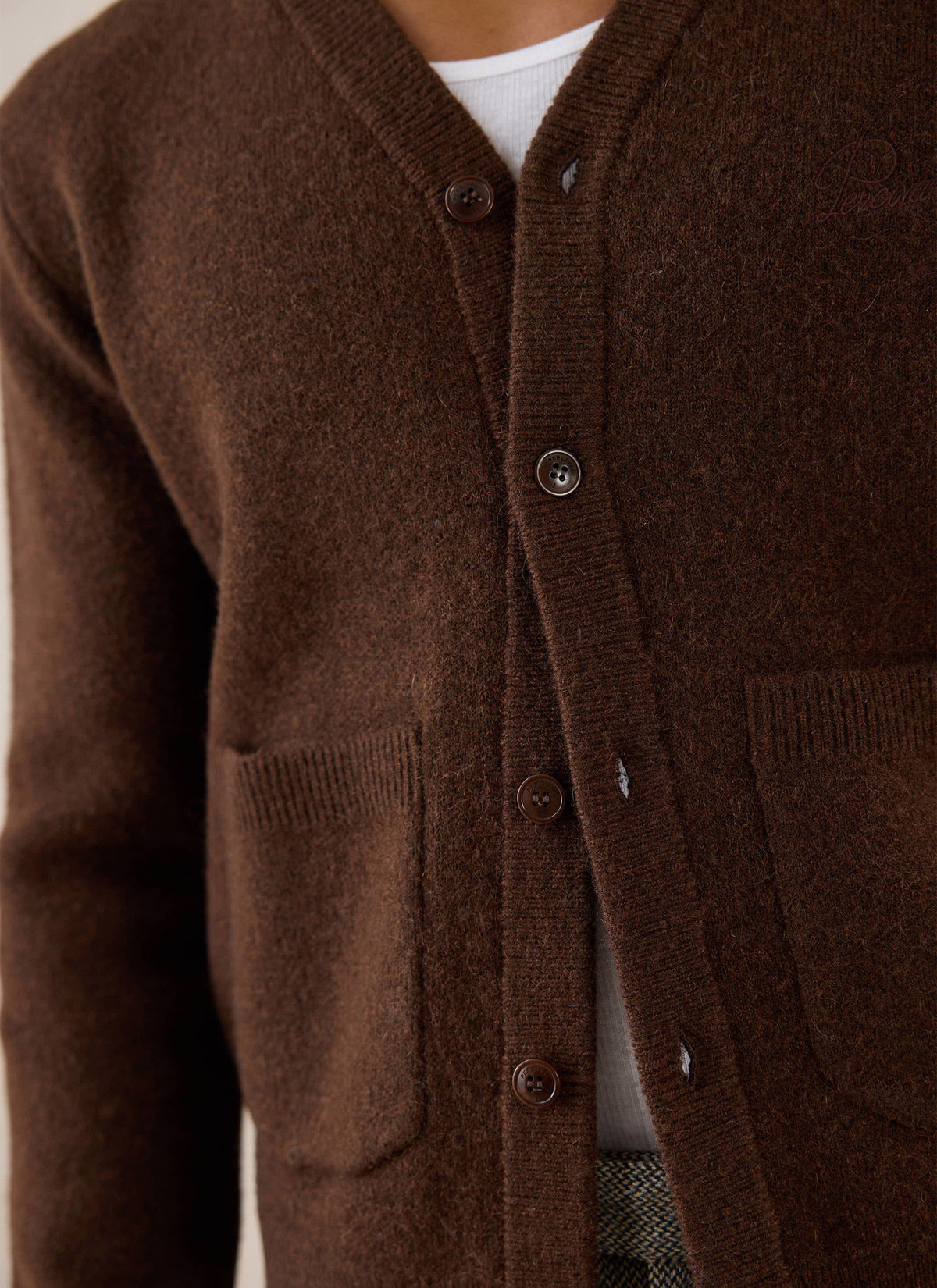 Close-up of the espresso brown Percival White Glove mohair cardigan, showing branded buttons and front patch pockets.