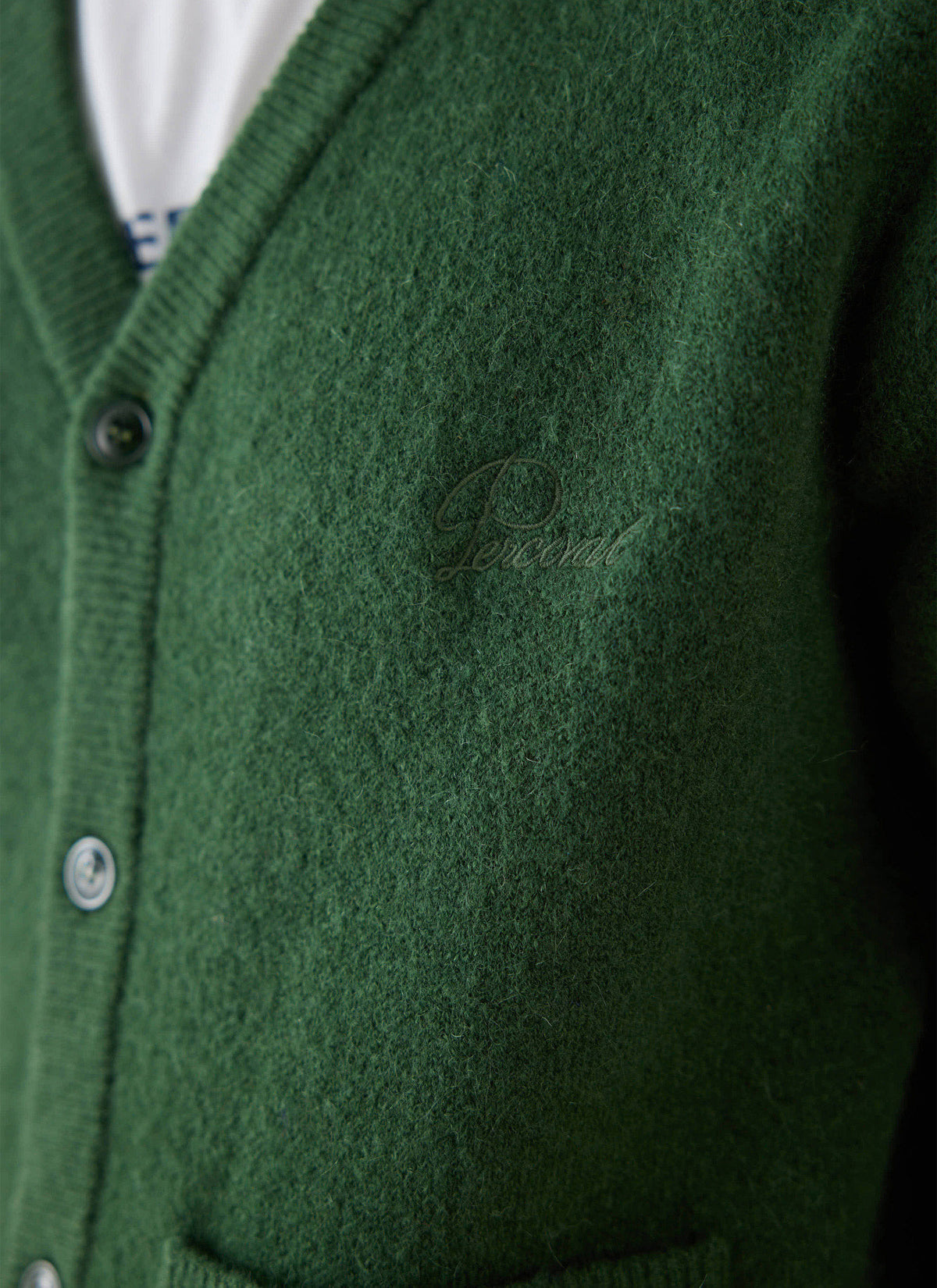 Close-up of the forest green Percival mohair cardigan showing the tonal chest embroidery and buttons.