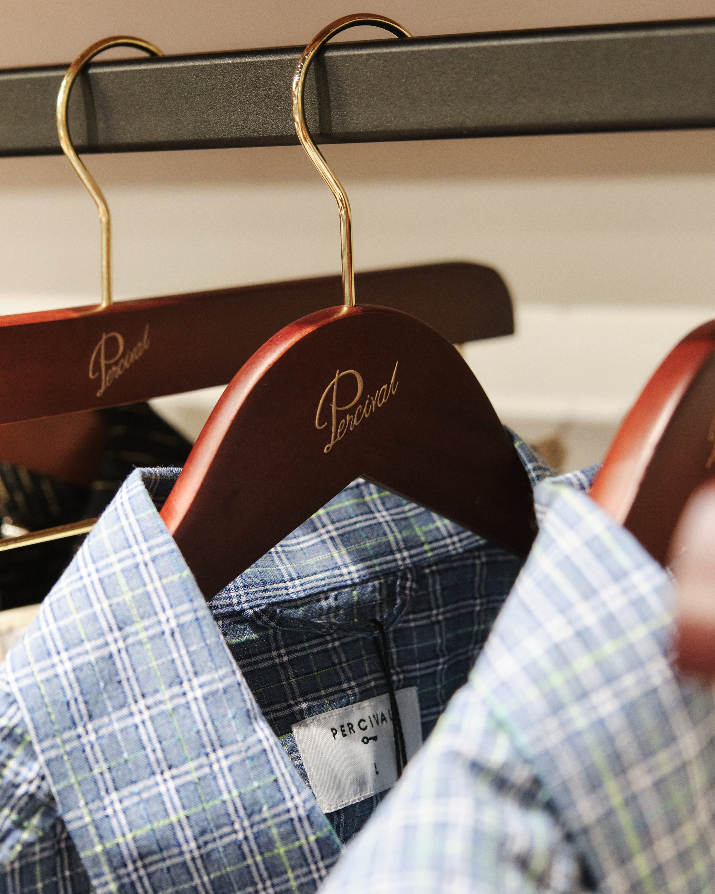 Men's plaid Hinsley shirt on a wooden hanger featuring the Percival brand logo at the Selfridges Birmingham pop-up store