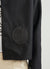 black jacket with black embroidery of and ice cream and a tomato