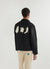 black jacket with cream embroidery on the back of an aubergine, chilli and pepper