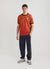 red football shirt with diamond shapes styled with navy jacquard track pants and sneakers