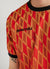 red football shirt with diamond shapes and percival logo on right side of chest