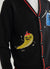 black cardigan with a yellow chilli and blue pepper on the front, and a tomato on the back