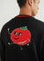 black cardigan with a yellow chilli and blue pepper on the front, and a tomato on the back