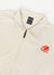 Ecru track jacket with orange octopus embroidery on left chest, close up