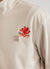 Ecru track jacket with orange octopus embroidery on left chest, close up