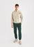 Ecru track jacket with orange octopus embroidery on left chest, styled with forest green track pants