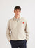 Ecru track jacket with orange octopus embroidery on left chest, worn closed
