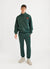 Forest green trackpants with orange octopus embroidery on left thigh styled with matching forest green track jacket